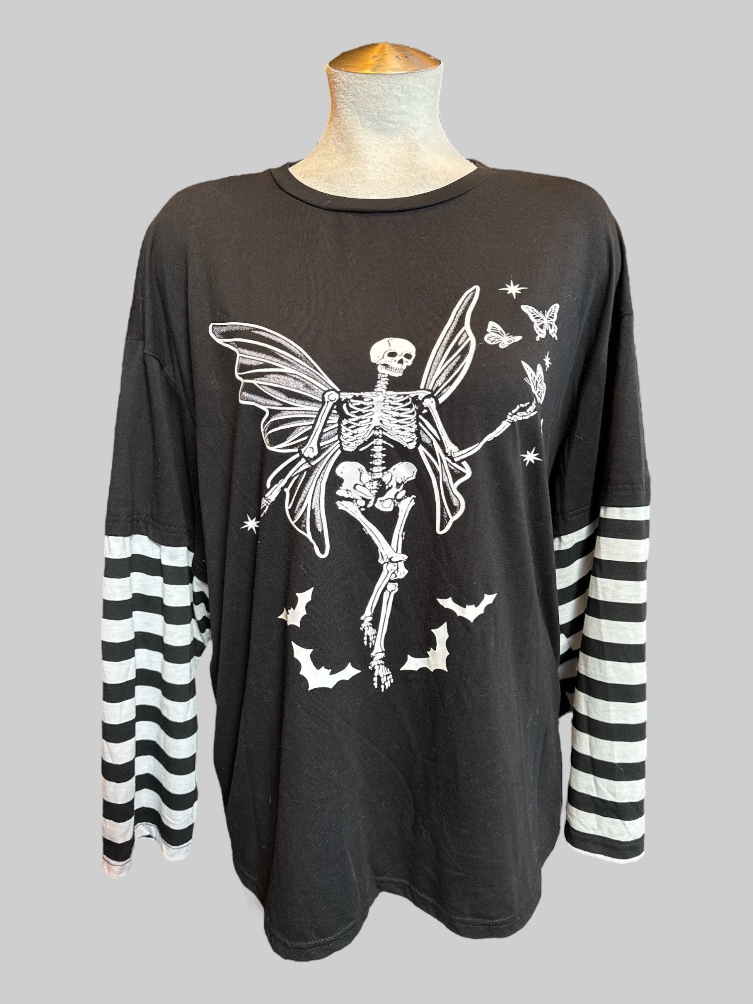 2X Black long sleeve top with skeleton fairy graphic, and black and white striped sleeves
