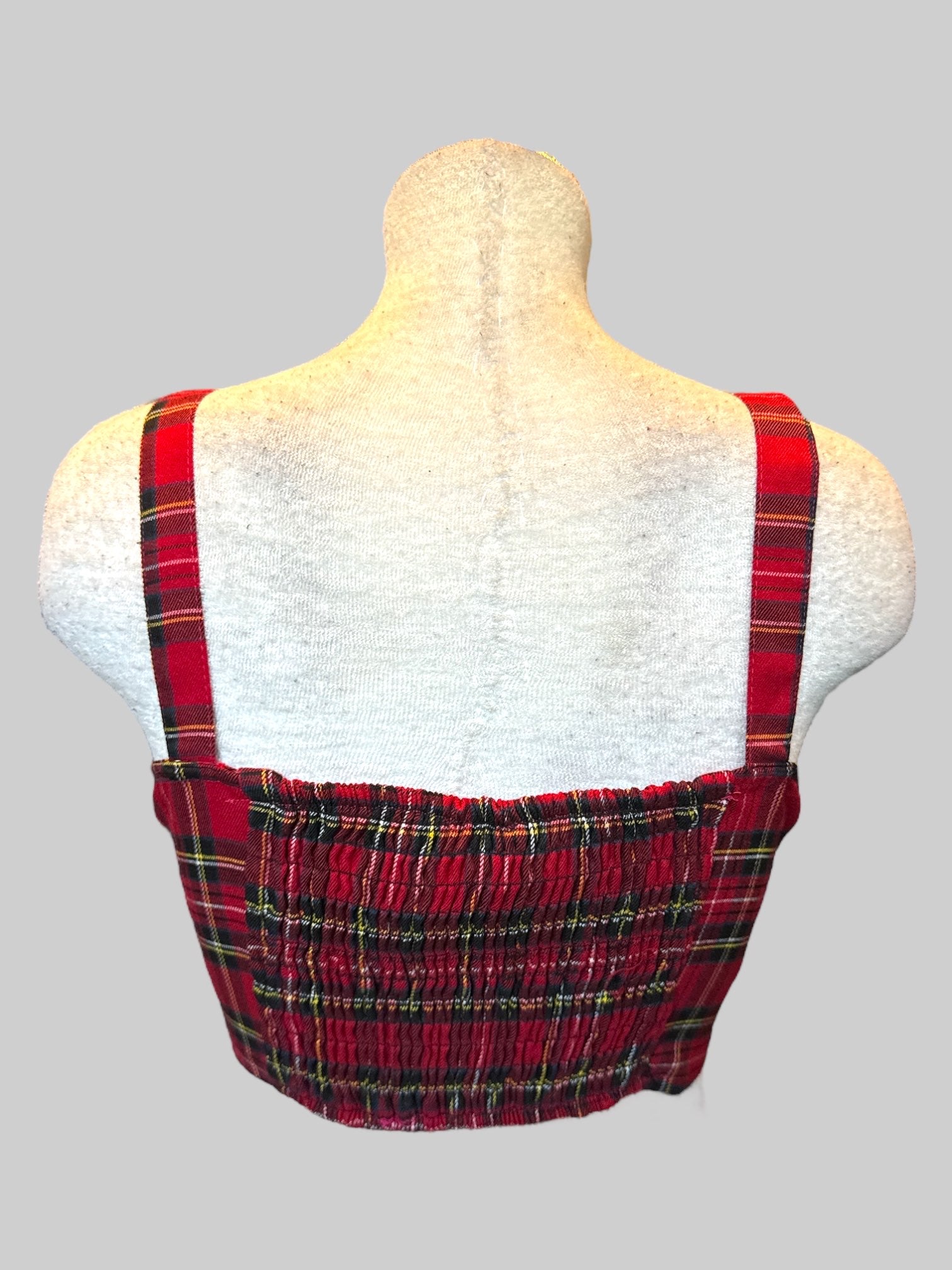L red, black, white, yellow, and blue plaid crop top with corset style front, buckle straps, and shirred back