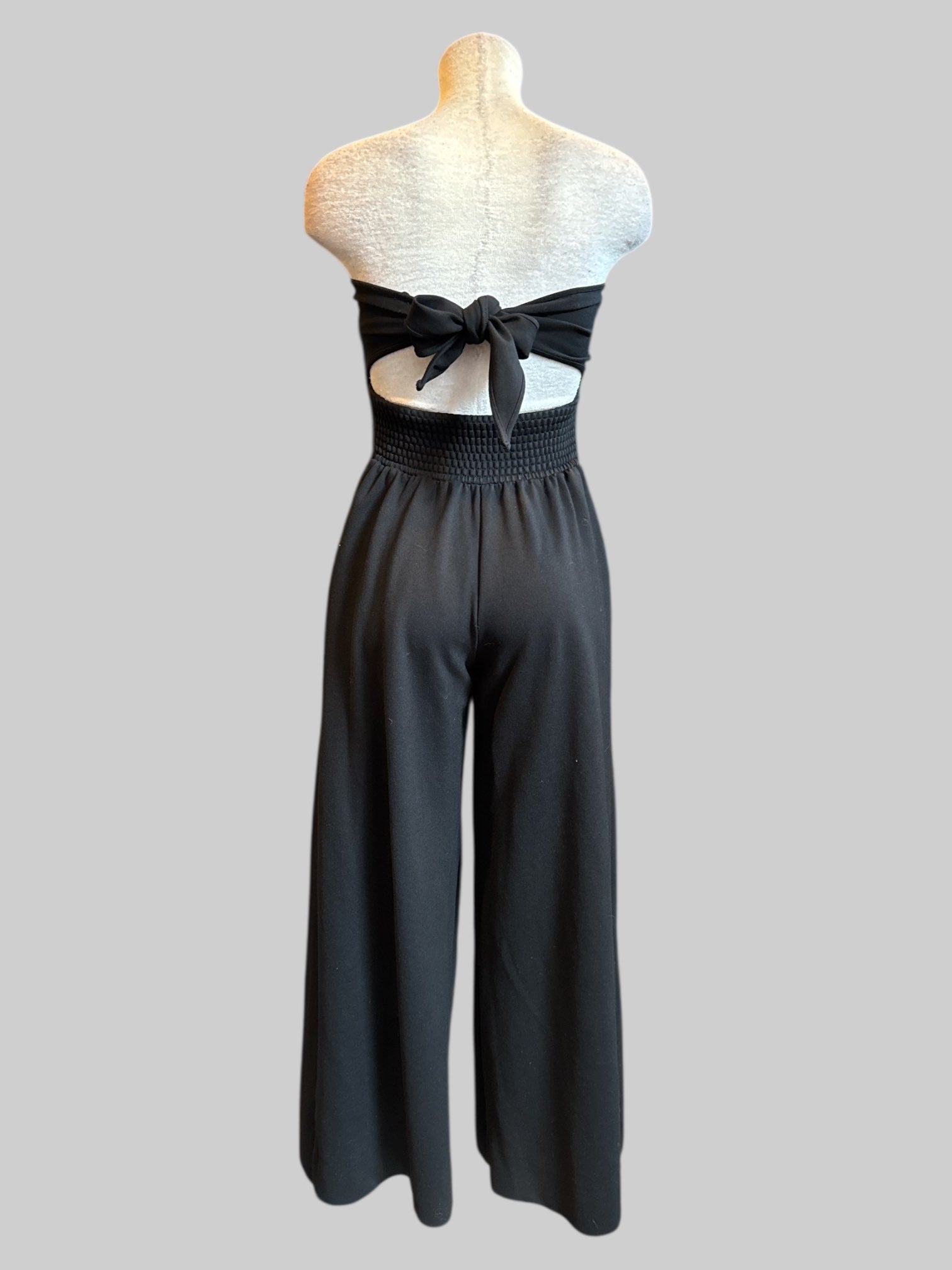 XS Free People black strapless jumpsuit with corset boning, back cut out, and bow