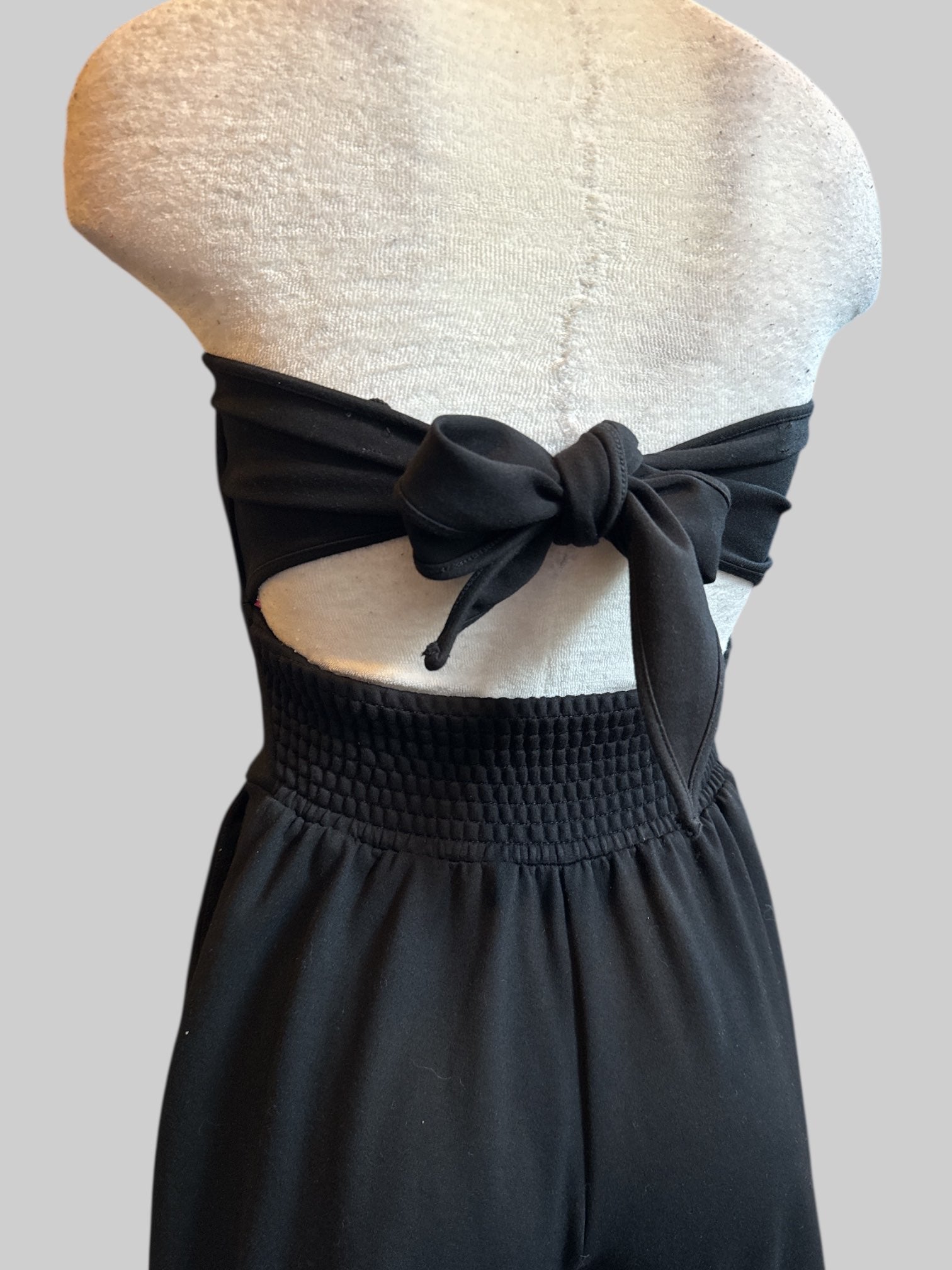 XS Free People black strapless jumpsuit with corset boning, back cut out, and bow