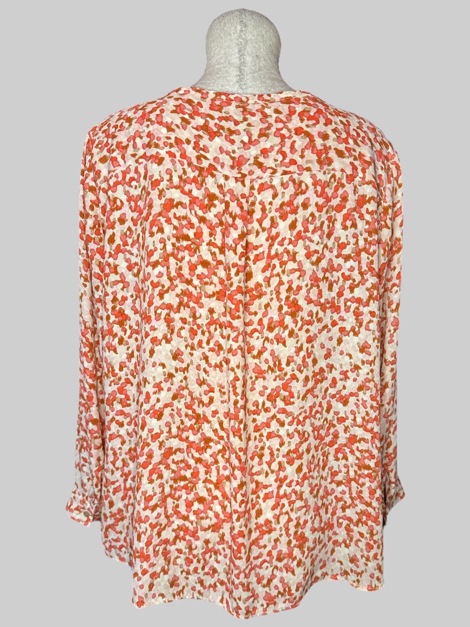 1X Off-white top with pink and brown spots, pleated design on front, and buttons on sleeves