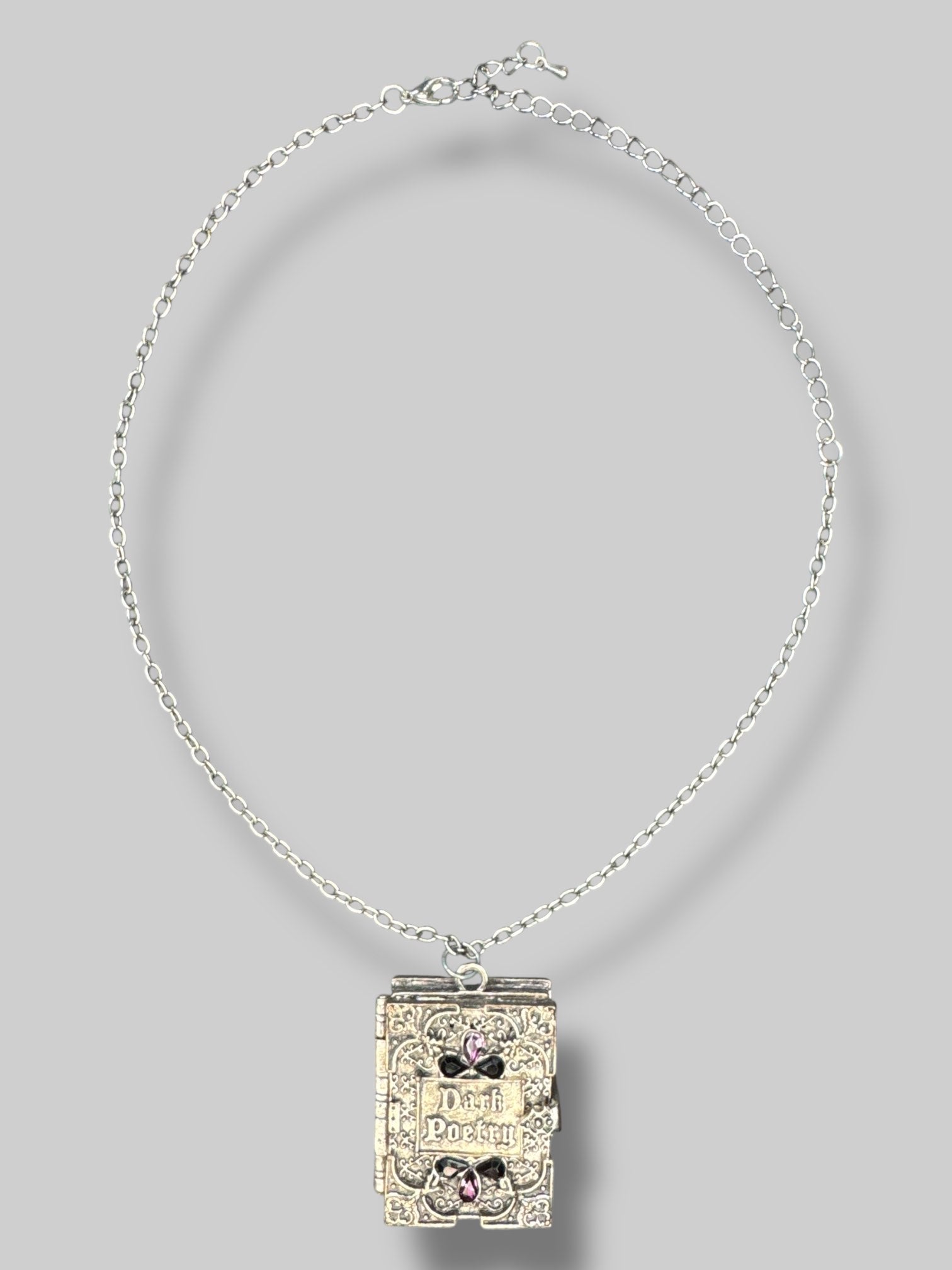 Silver tone “Dark poetry” book locket with purple and black gems on front