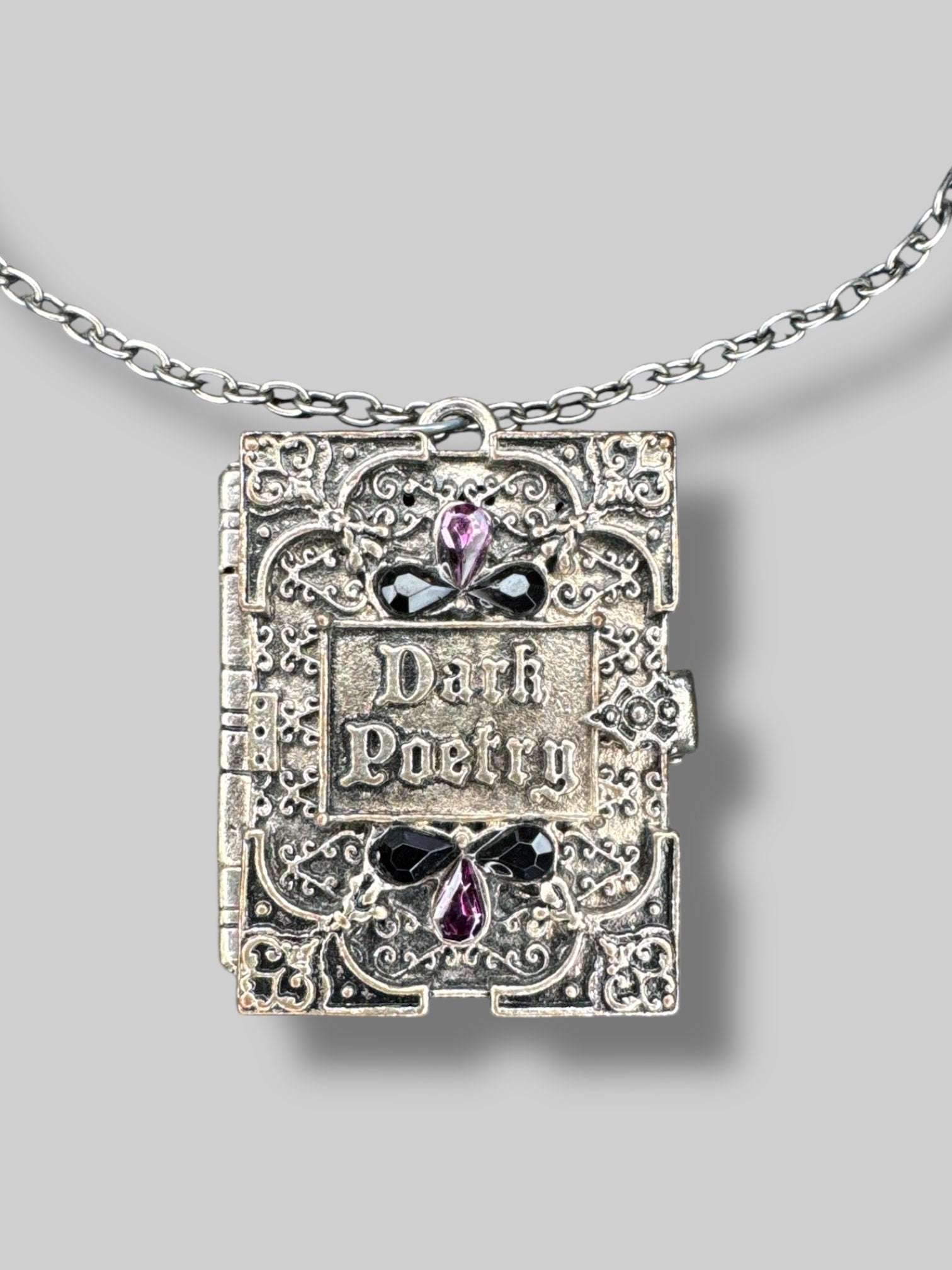 Silver tone “Dark poetry” book locket with purple and black gems on front