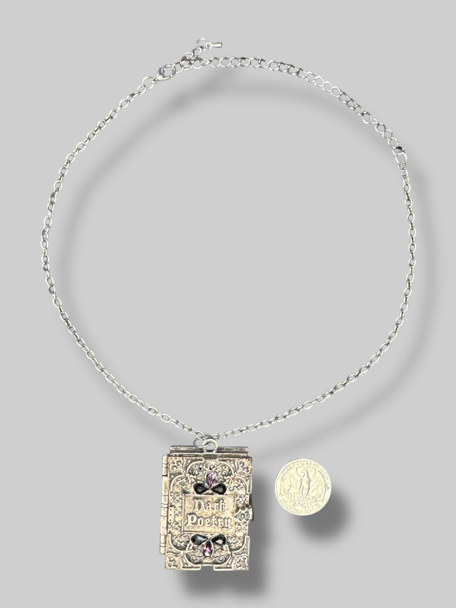 Silver tone “Dark poetry” book locket with purple and black gems on front