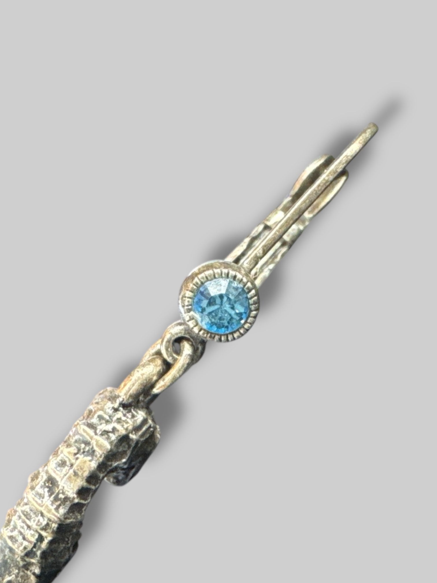 Silvertone seahorse dangle earrings with blue bead on bottom and blue gem on clasp closure