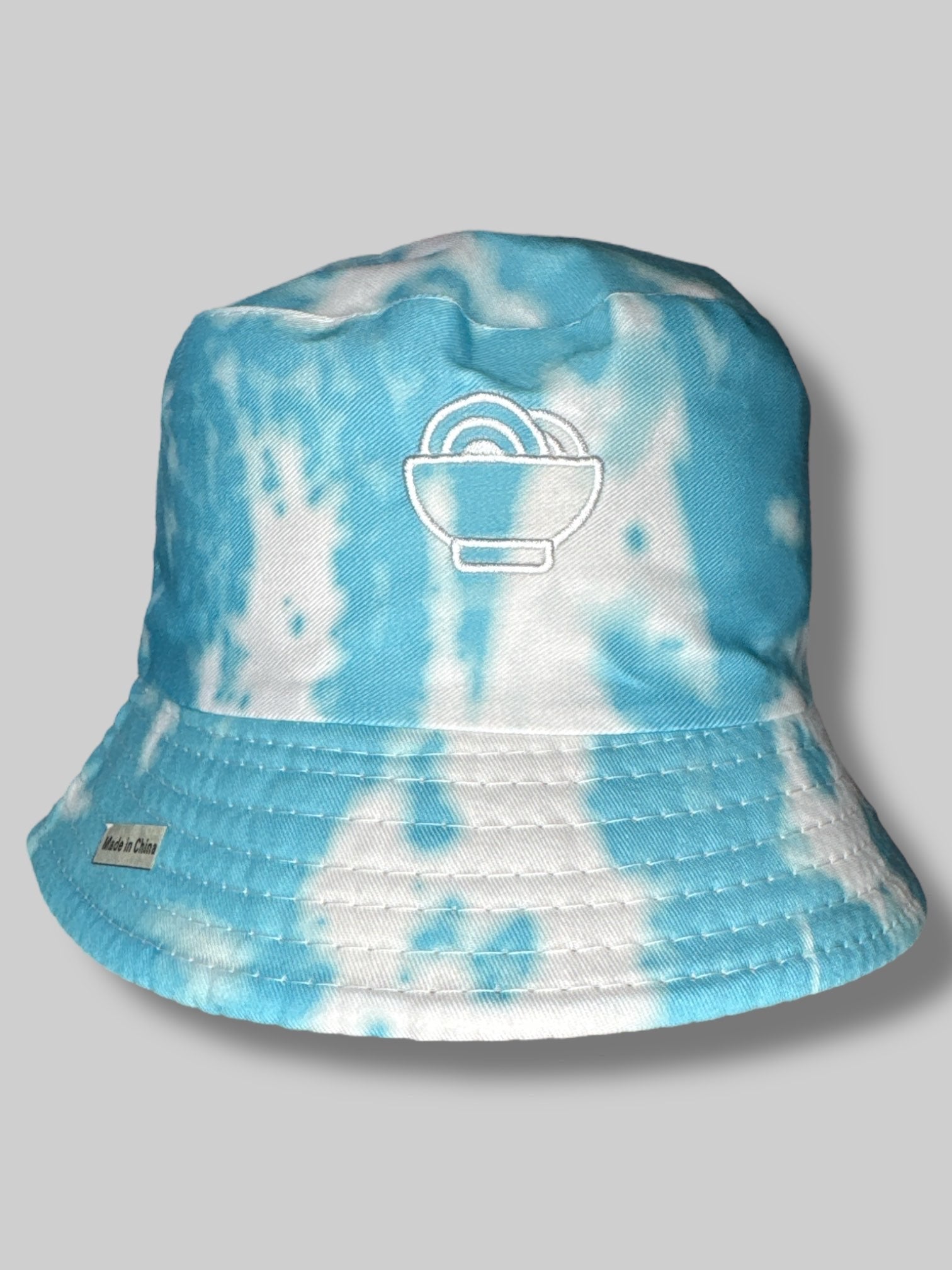 Reversible “Snackpass” bucket hat with one side white with black embroidery, other side with blue and white tie-dye with white embroidery