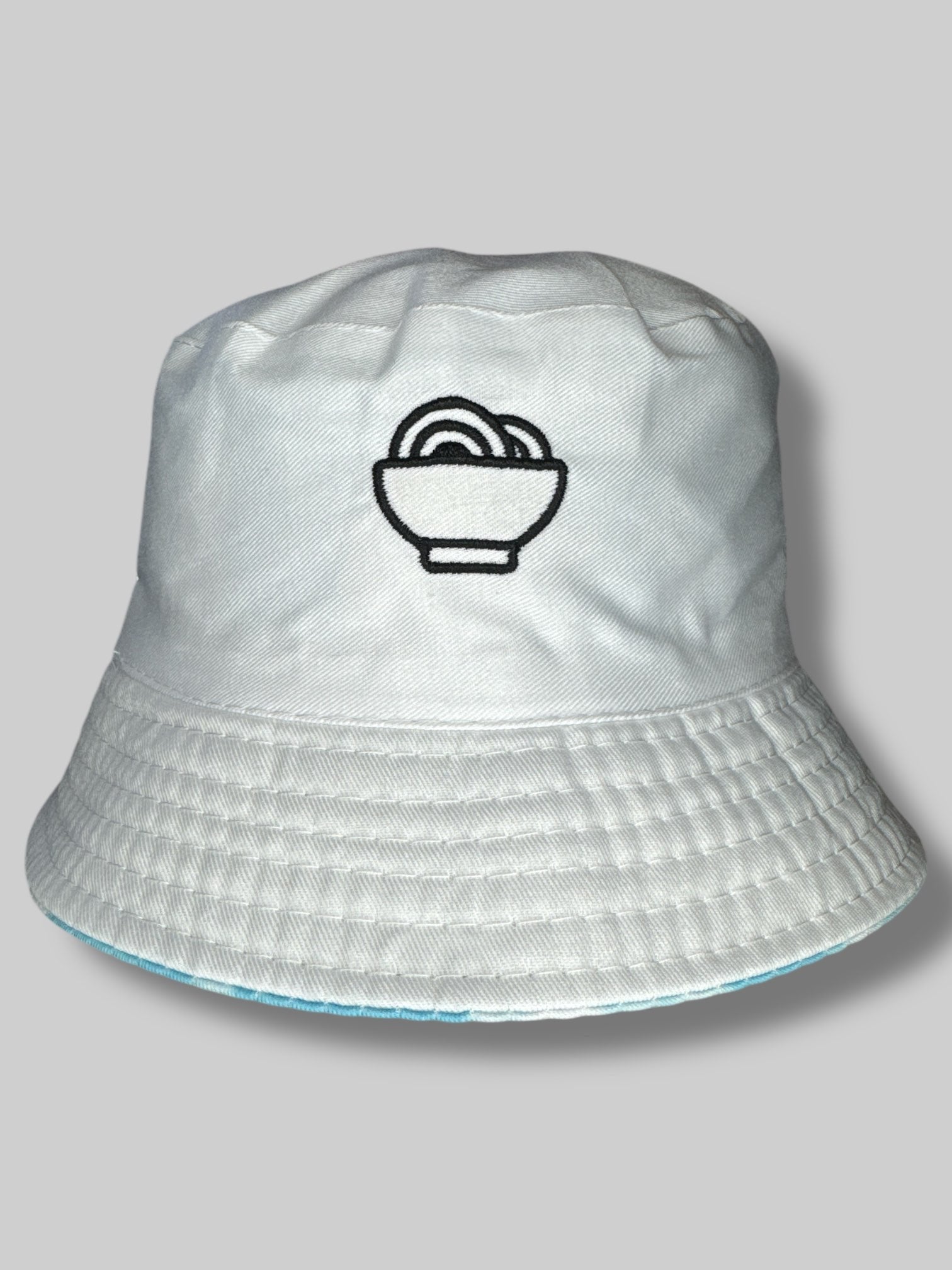 Reversible “Snackpass” bucket hat with one side white with black embroidery, other side with blue and white tie-dye with white embroidery