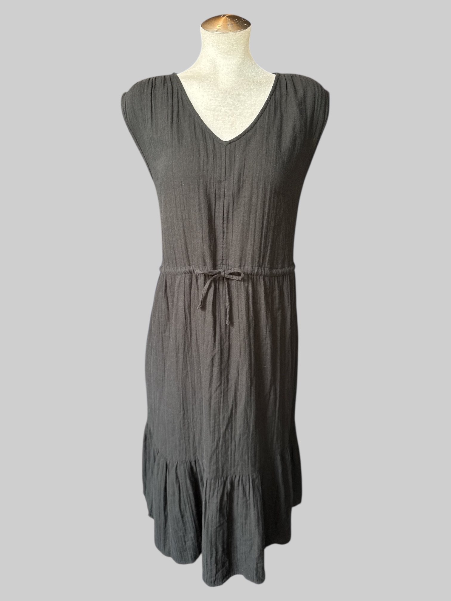 1X Black sleeveless dress with tiered design, drawstring on waist, and pockets