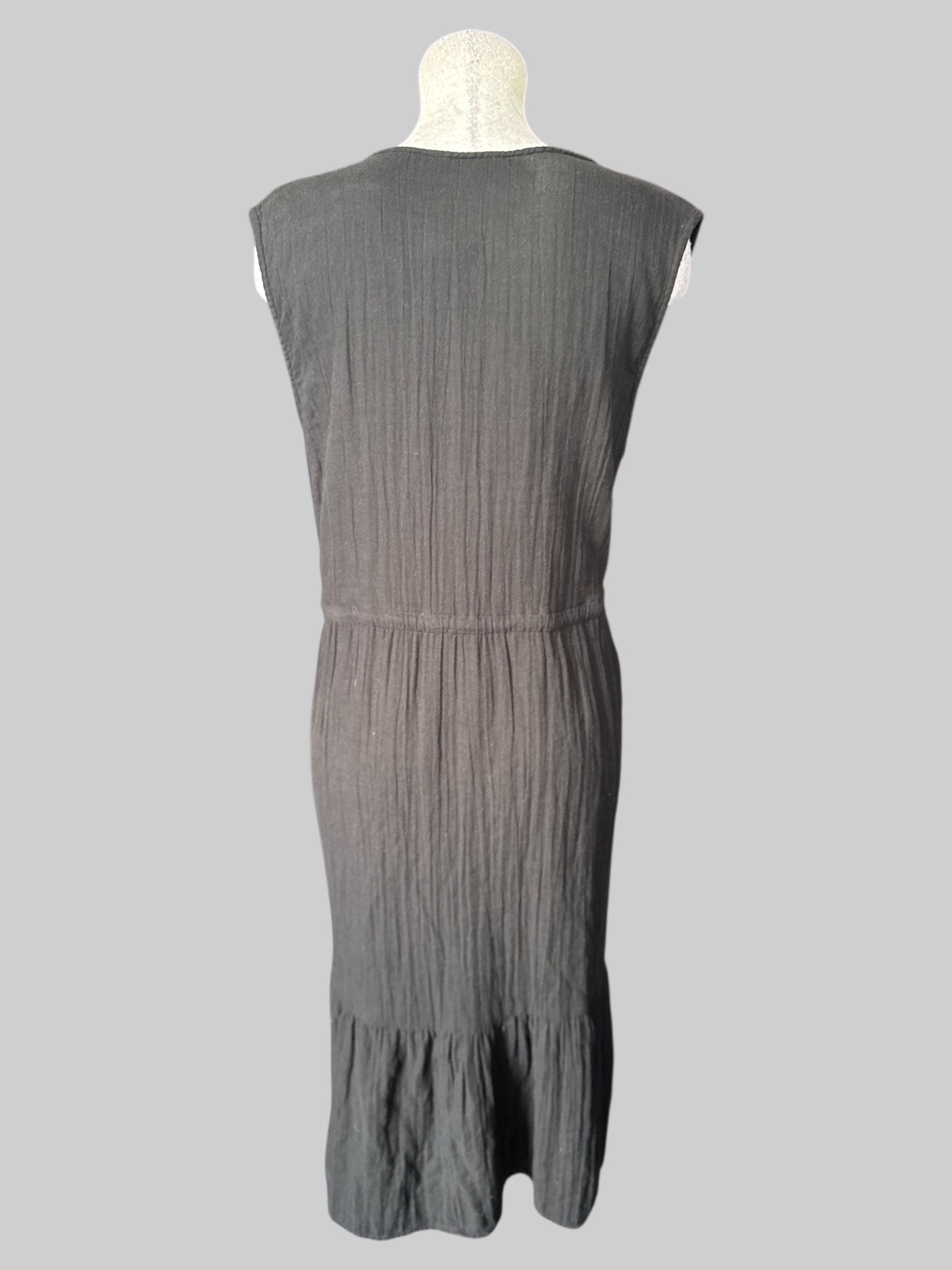 1X Black sleeveless dress with tiered design, drawstring on waist, and pockets