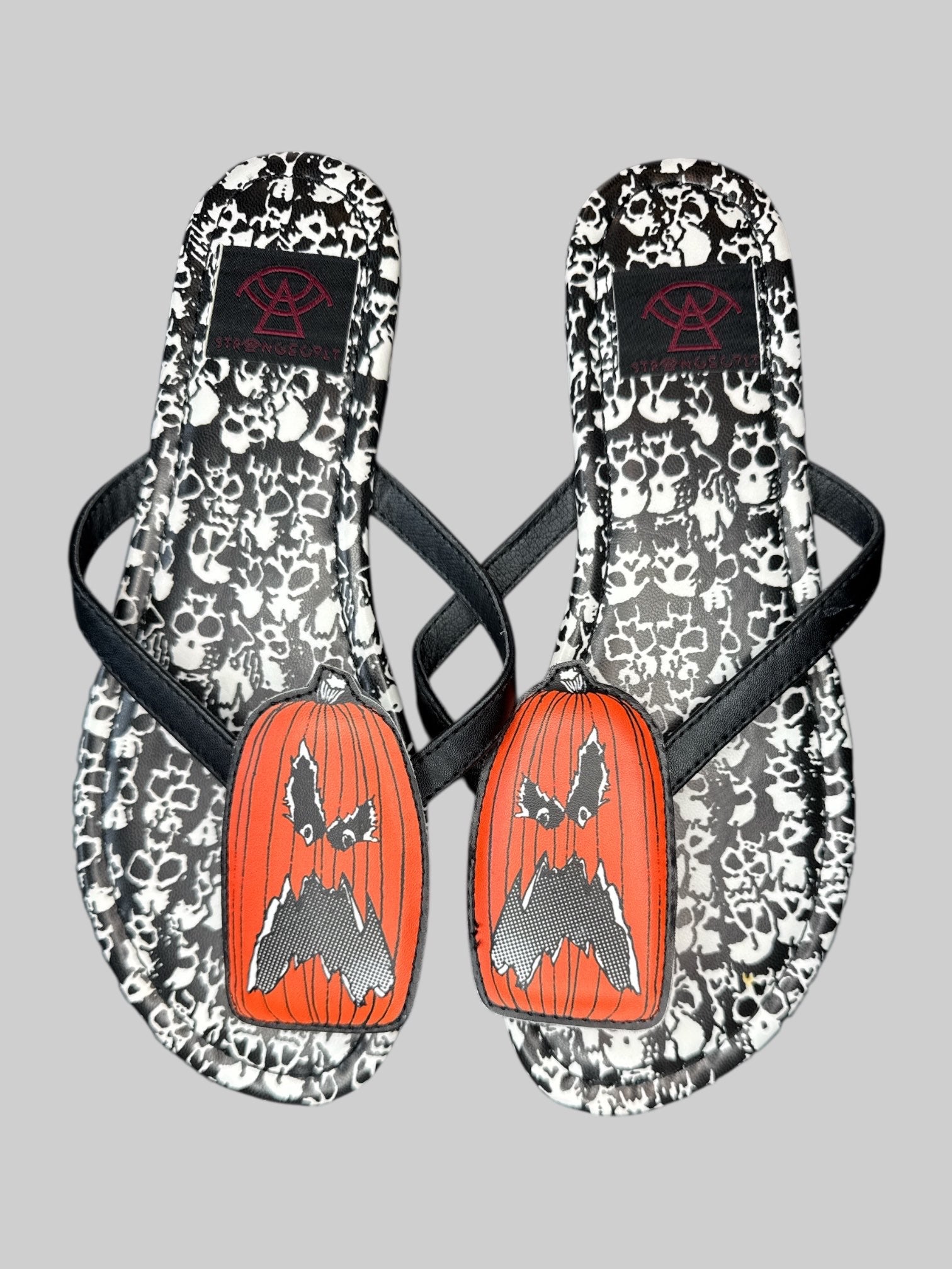Size 6 Strange Cult pumpkin and skull flip flops