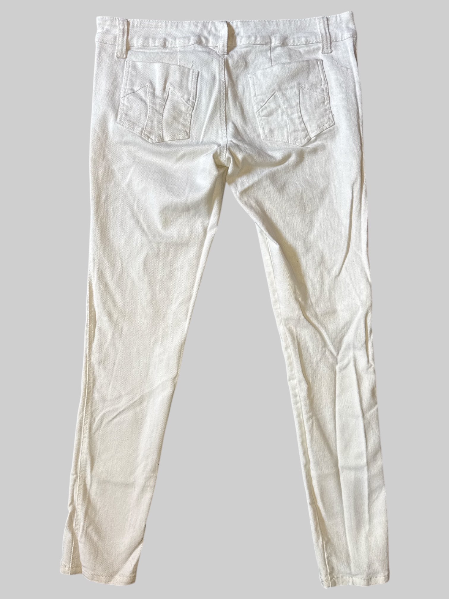 L White Tripp jeans with button closure on front, pockets, metal skull details, and T pockets on back