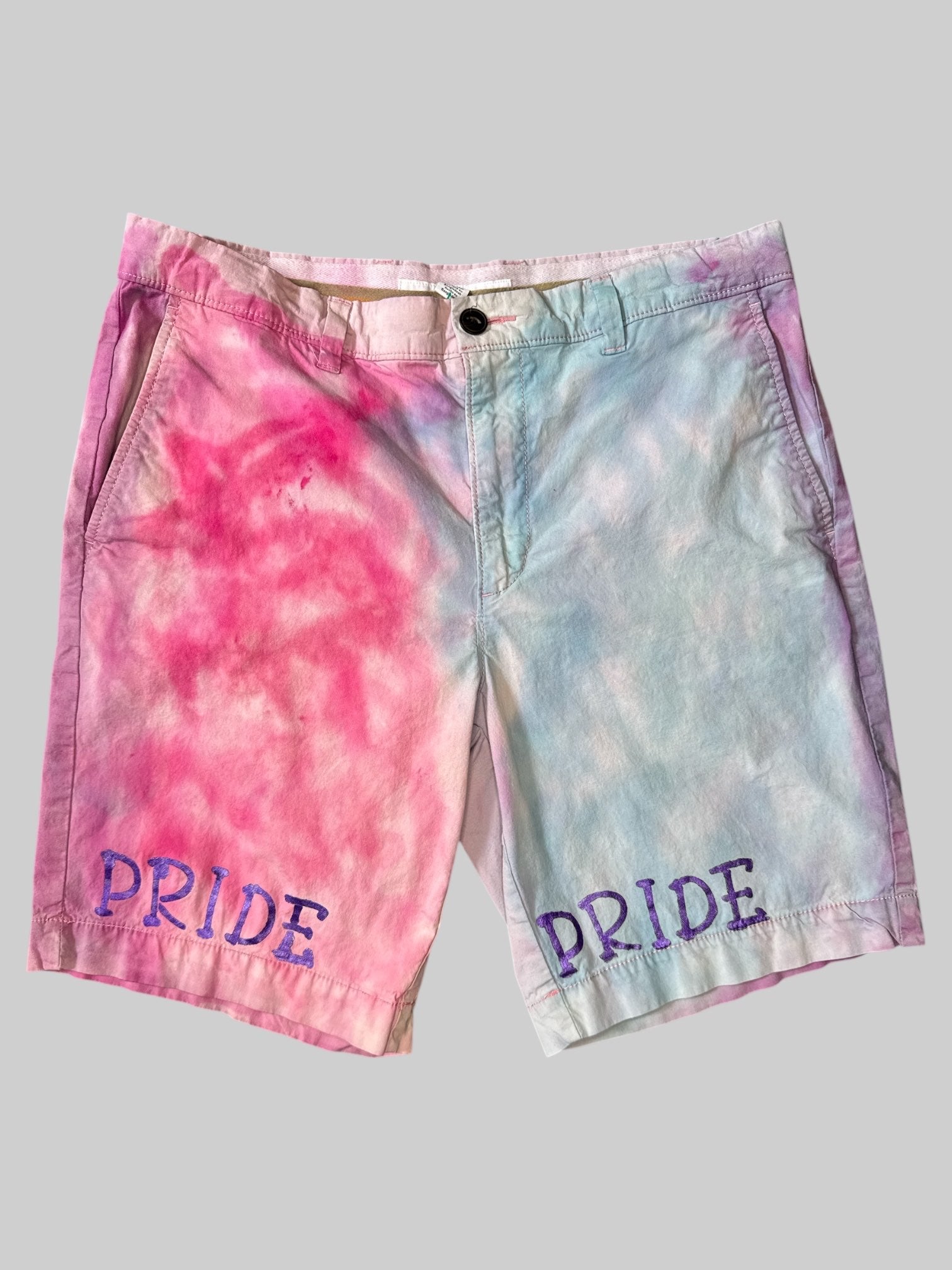 L Pink and light blue tie-dye shorts with purple “Pride” graphic on legs