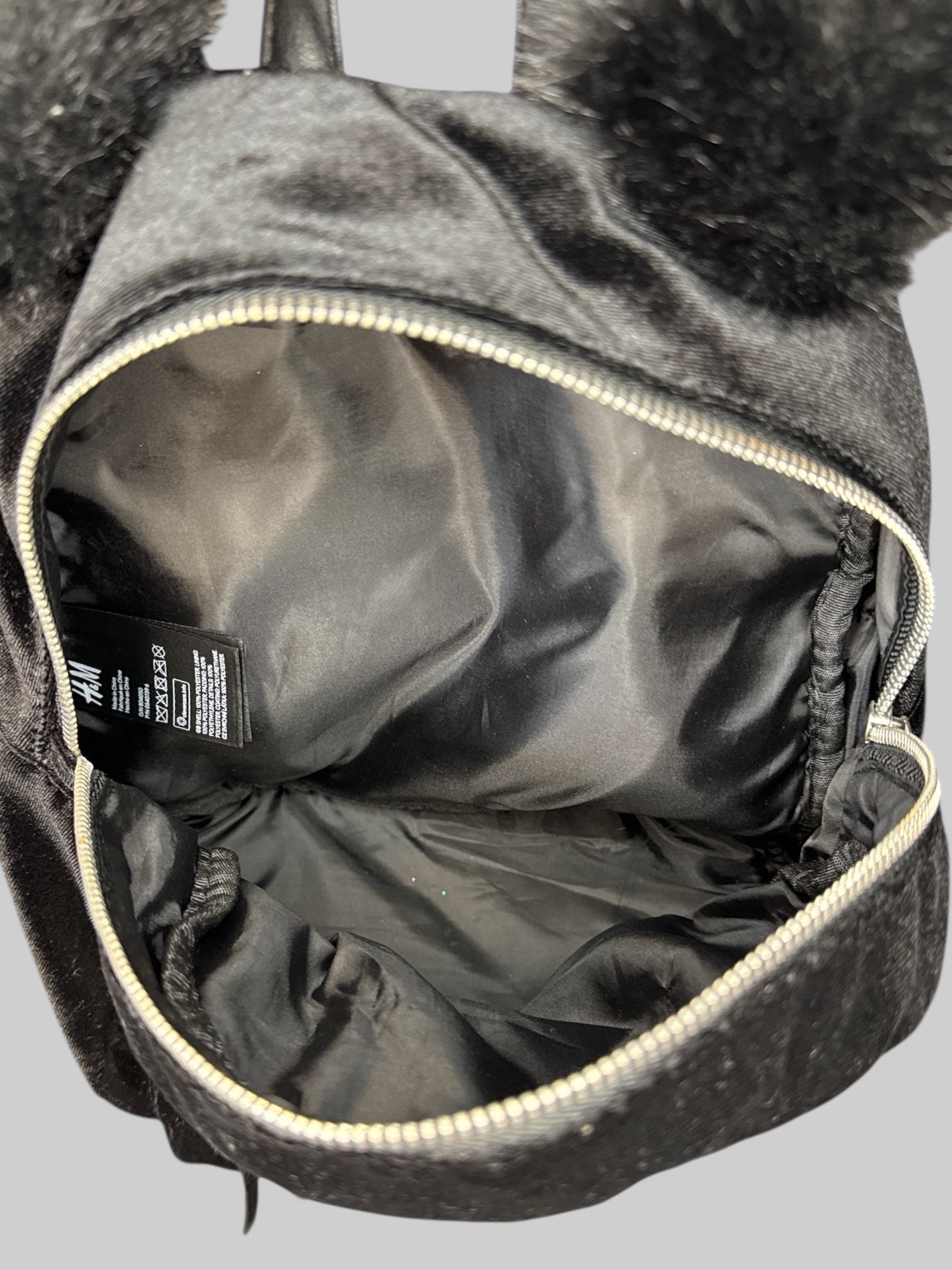 Black velvet small backpack with fuzzy ears on top, and multiple zipper pockets