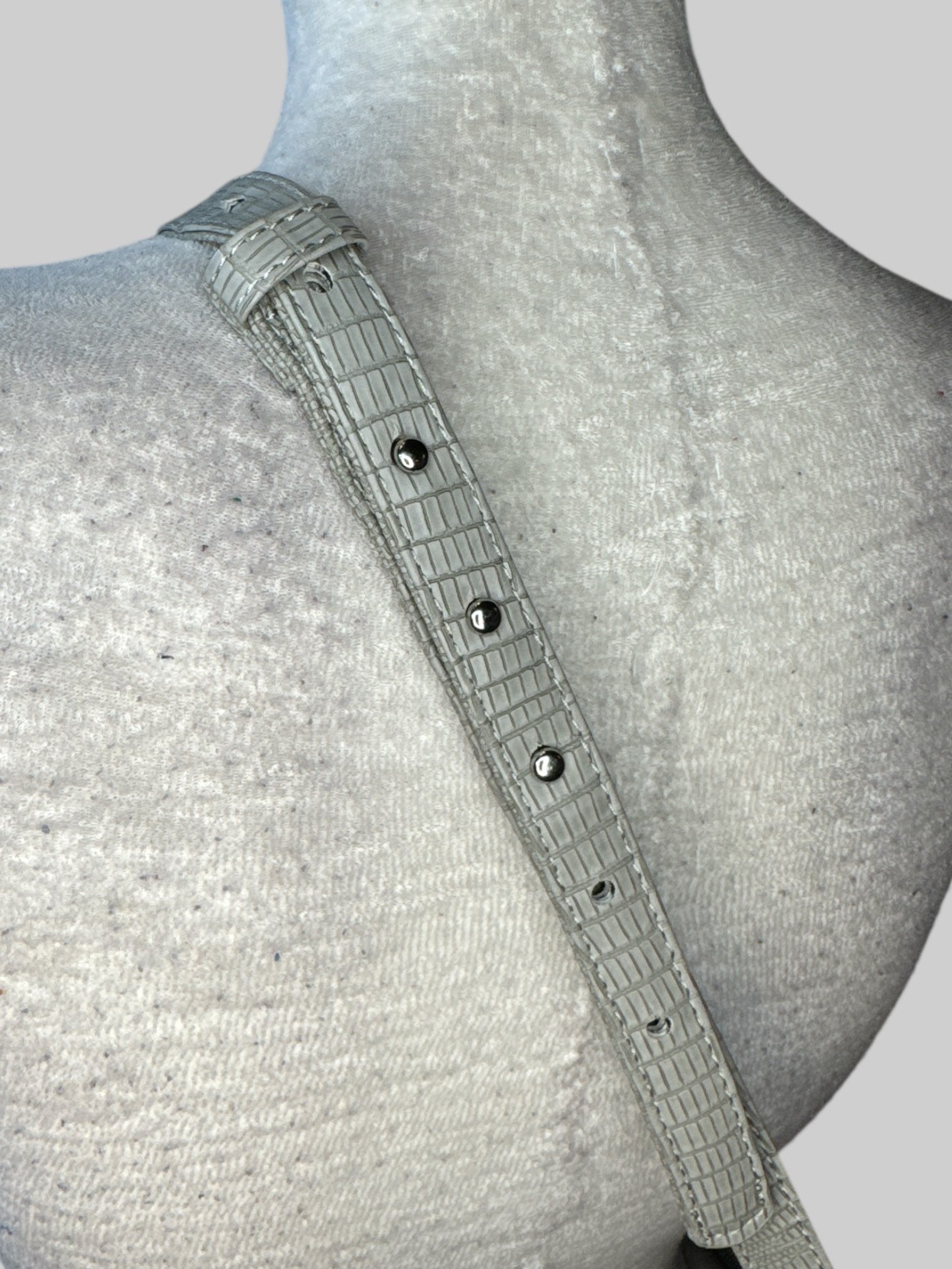 Grey leather laptop bag with shoulder strap, zipper pocket on the outside, and flip pocket