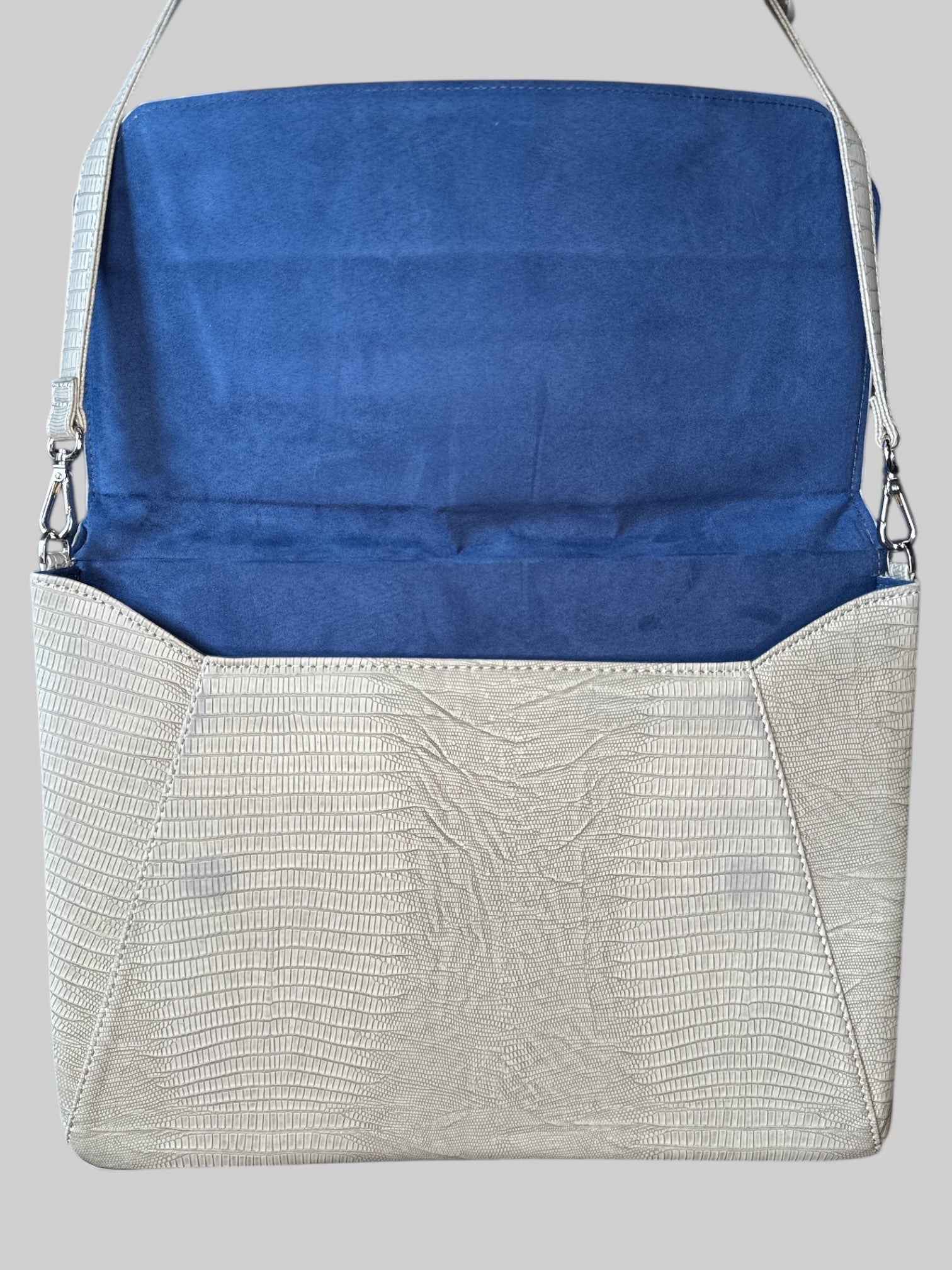 Grey leather laptop bag with shoulder strap, zipper pocket on the outside, and flip pocket
