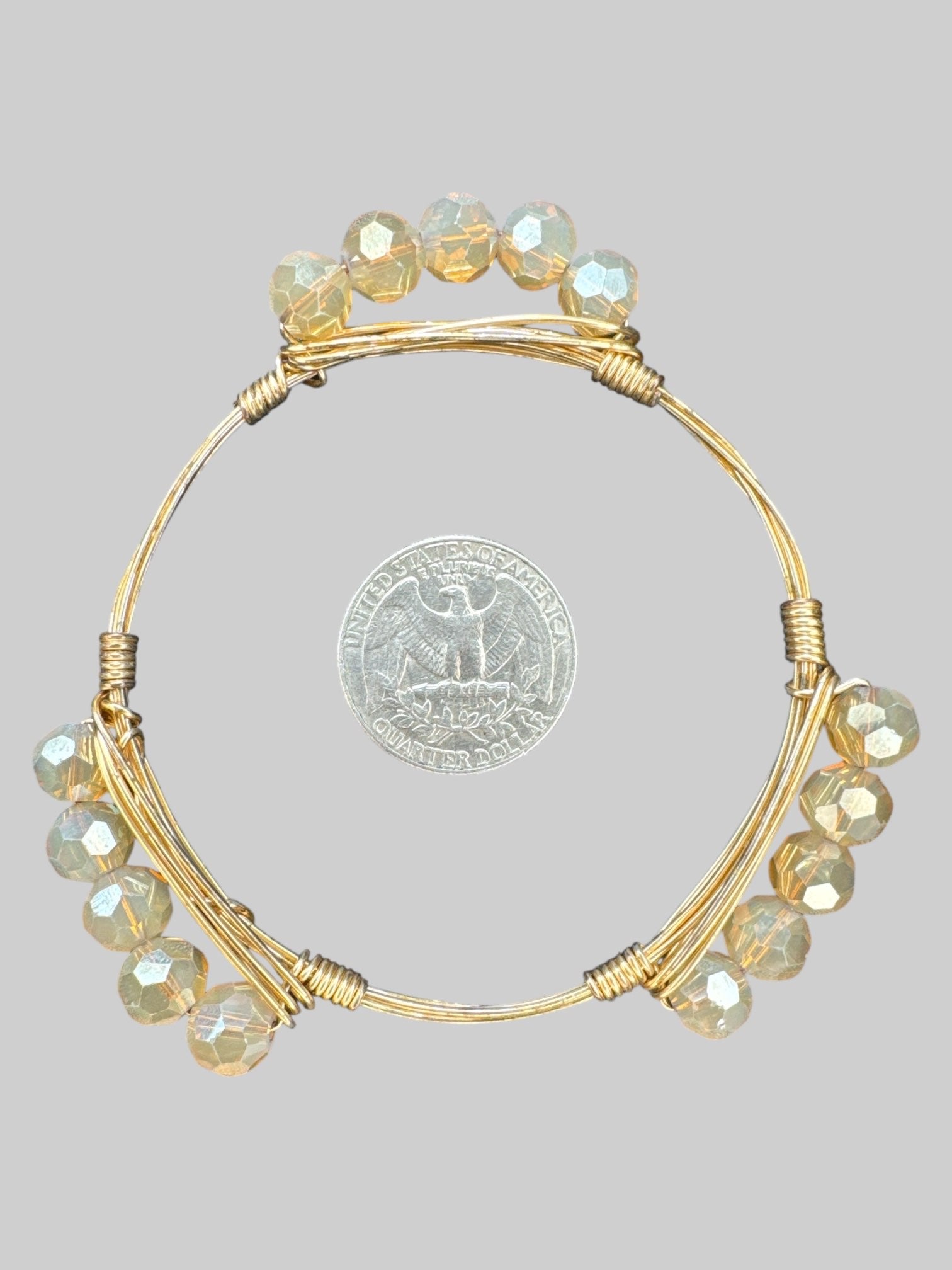 Gold tone wire wrapped bracelet with smoky colored beats