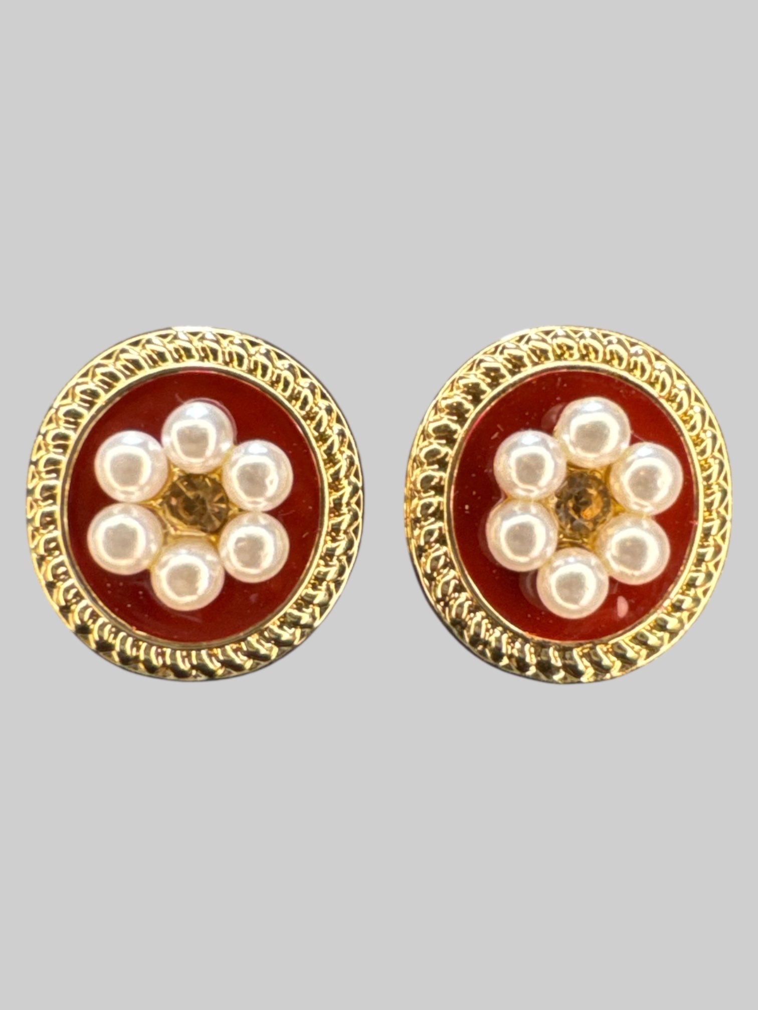Gold tone stud earrings with faux pearls, and red background