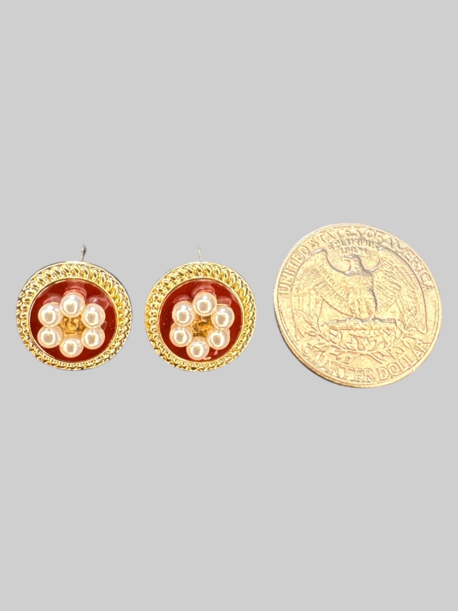 Gold tone stud earrings with faux pearls, and red background