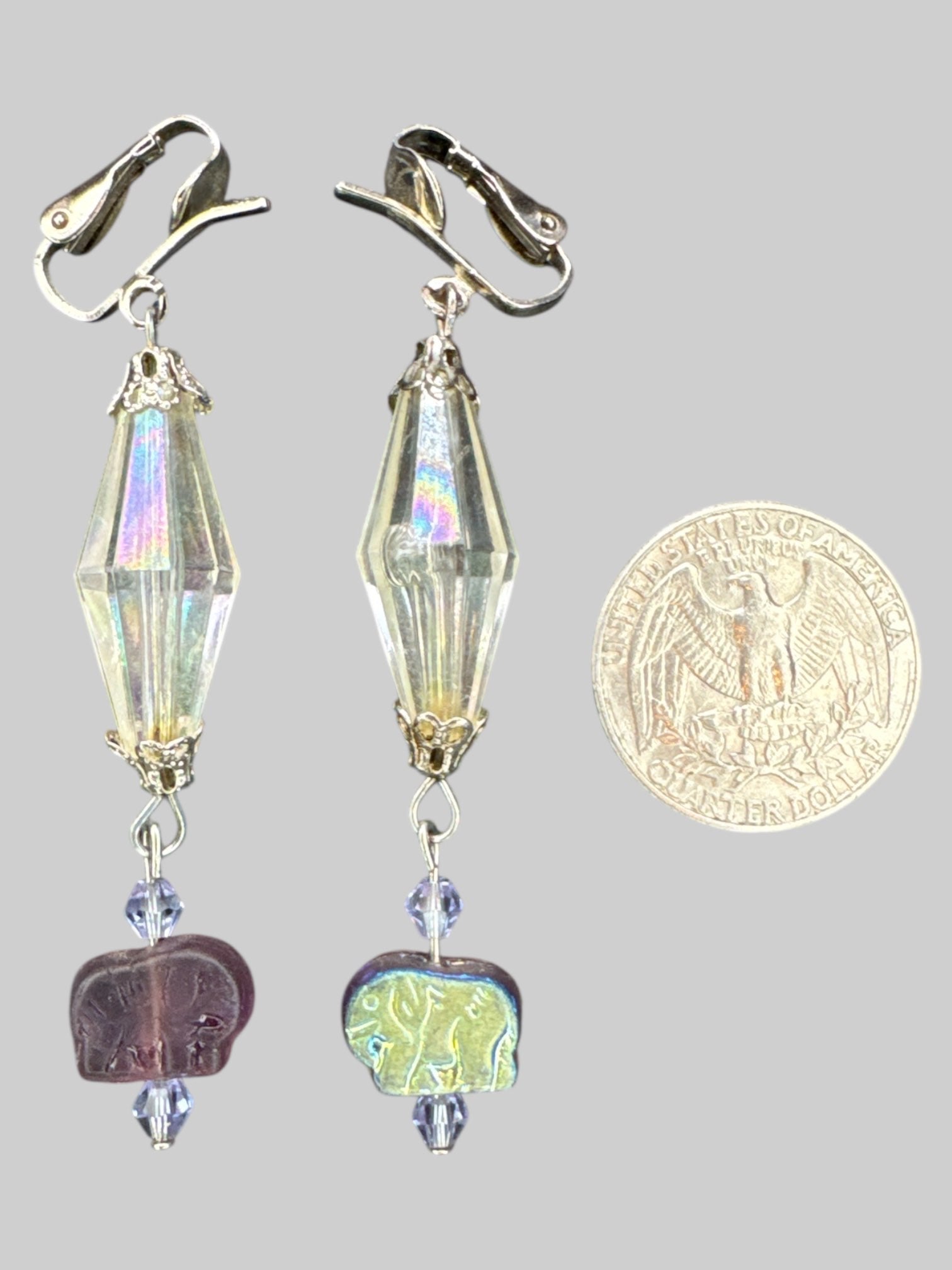 Silver tone dangly clip on earrings with larger iridescent clear gem, and purple and iridescent elephants