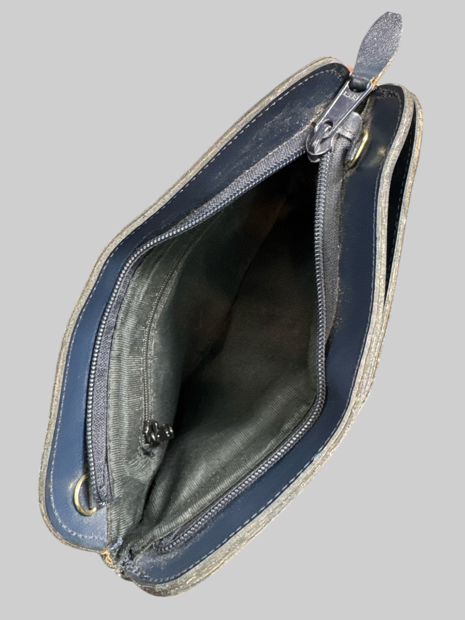 Blue leather handbag with faux drawstring on front, multiple zipper pockets, and hooks for shoulder strap