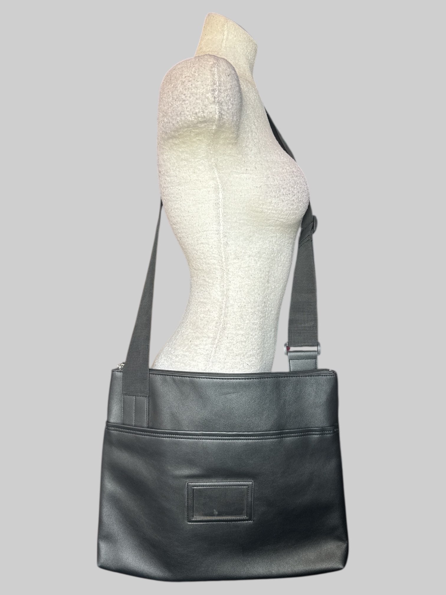 Black over the shoulder laptop bag with clear name tag slot on front, front velcro pocket, and large zipper pockets