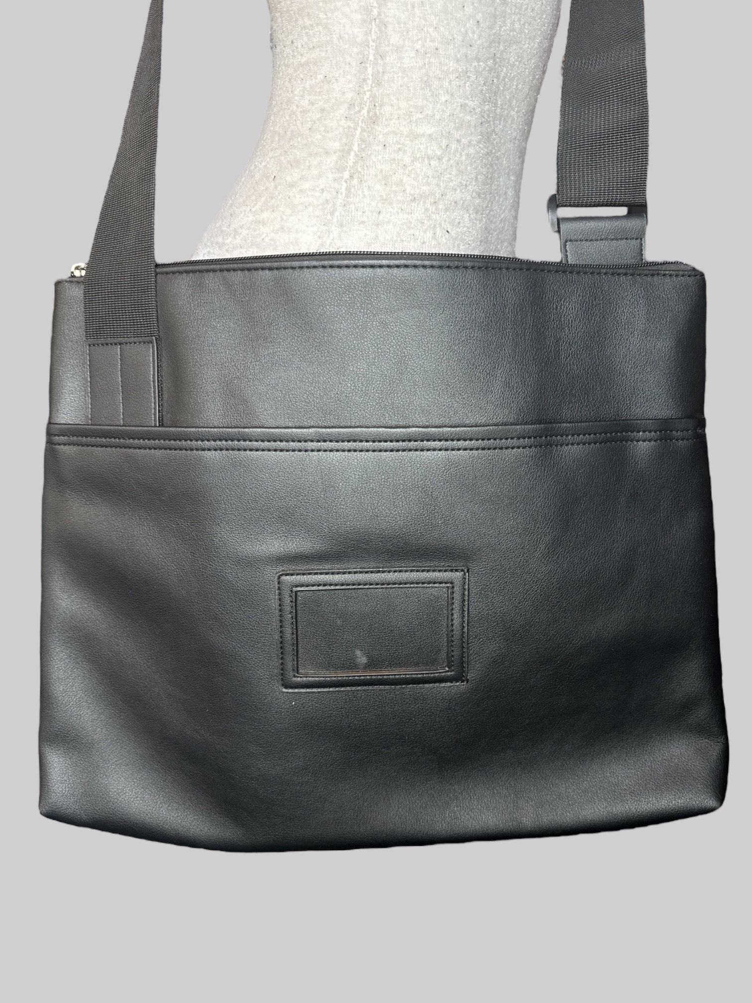 Black over the shoulder laptop bag with clear name tag slot on front, front velcro pocket, and large zipper pockets