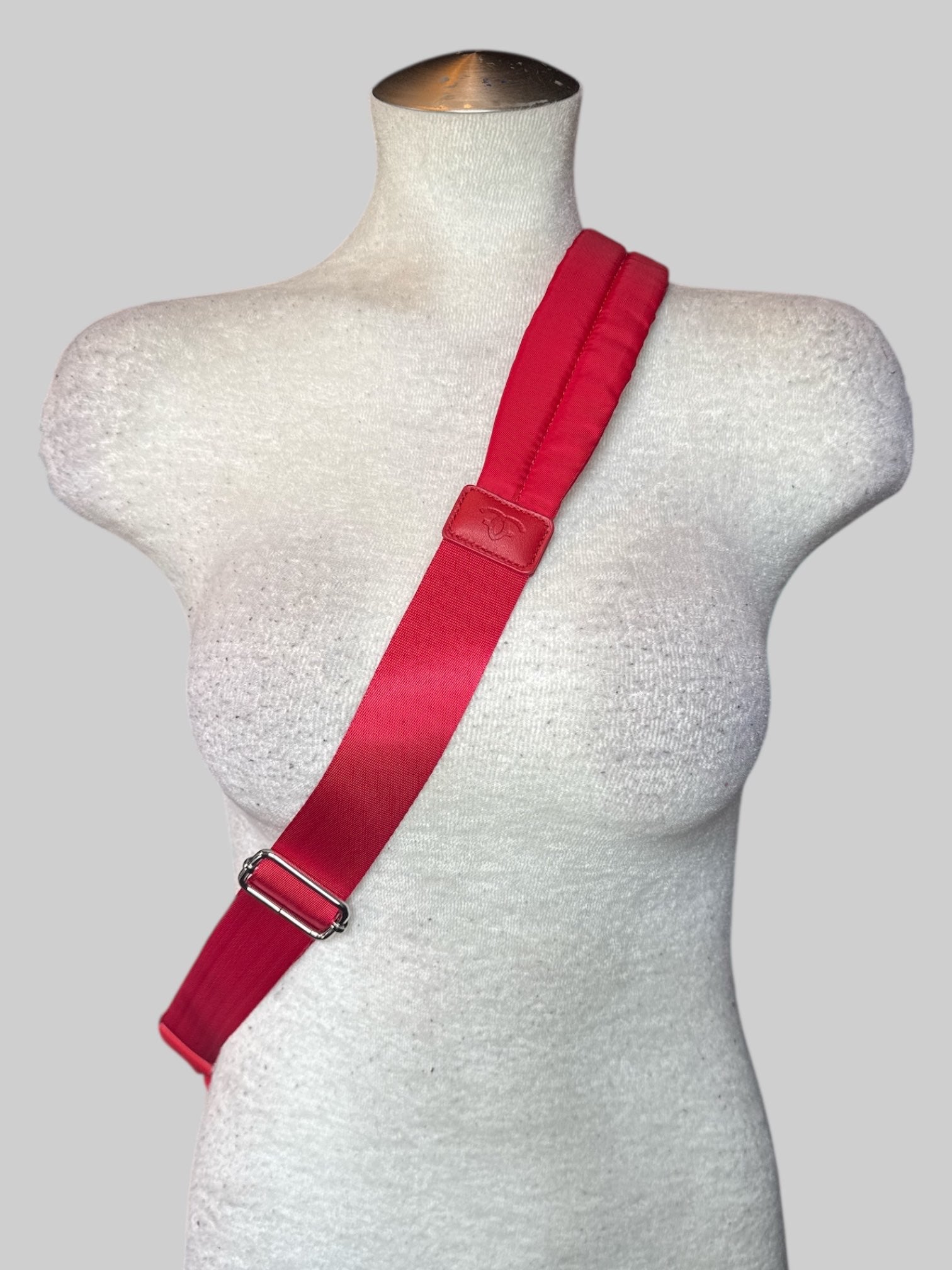 Red small backpack with one shoulder strap, and multiple pockets inside and out