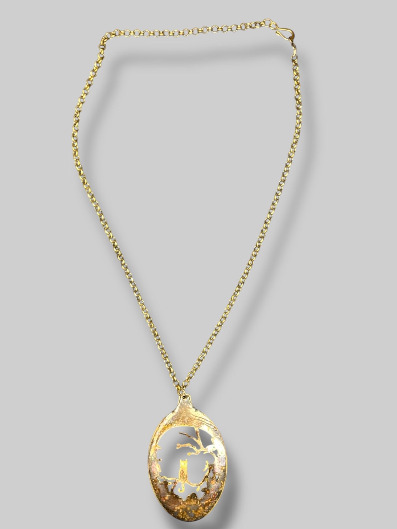 Gold tone necklace with cat and tree scene pendant