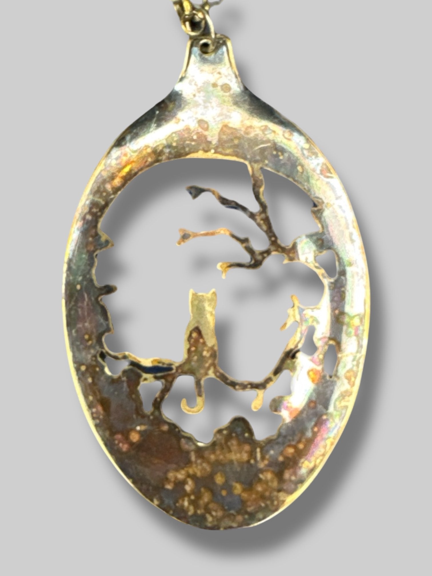 Gold tone necklace with cat and tree scene pendant