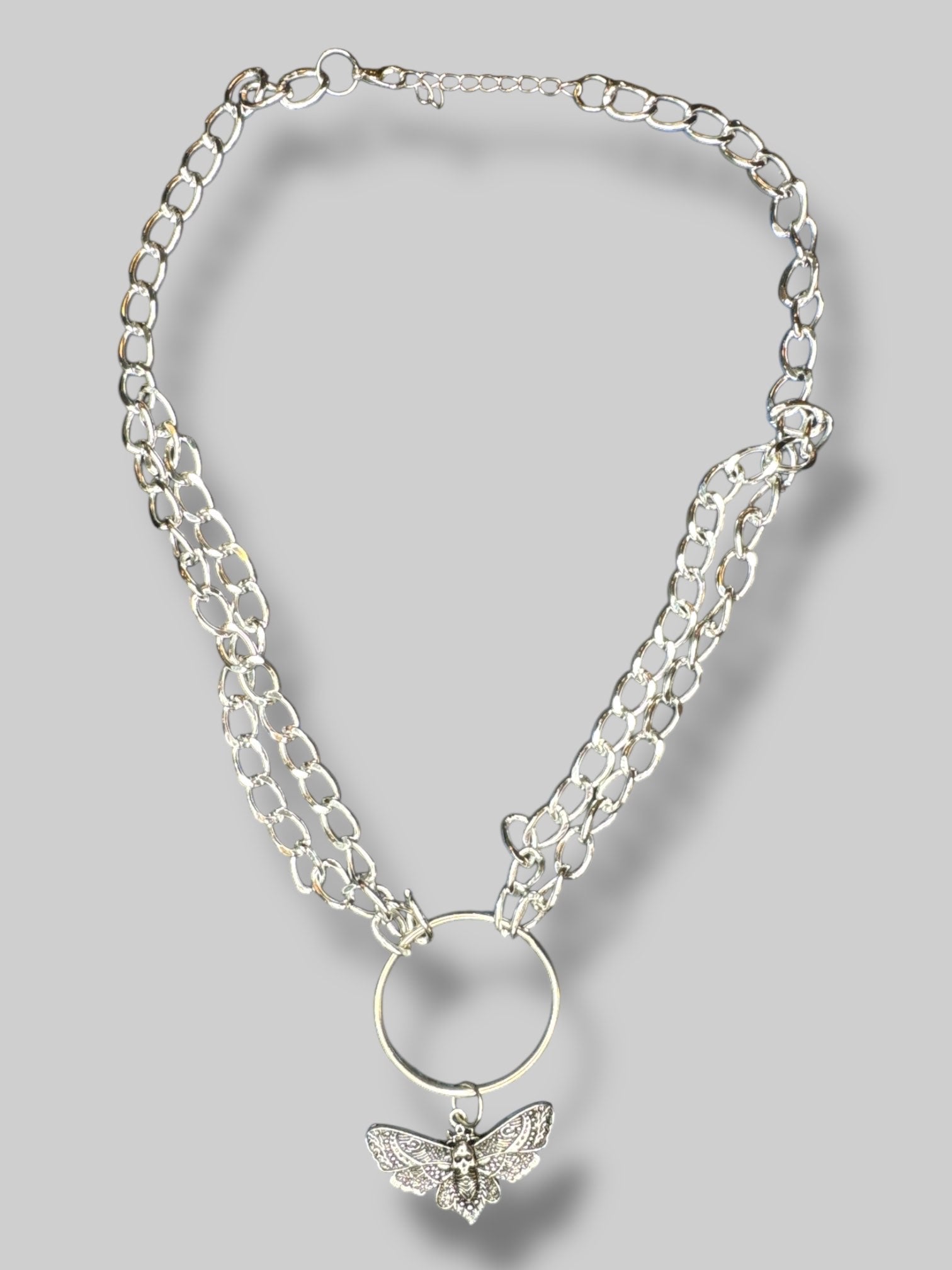 Silver tone chain link necklace with O ring and moth pendant