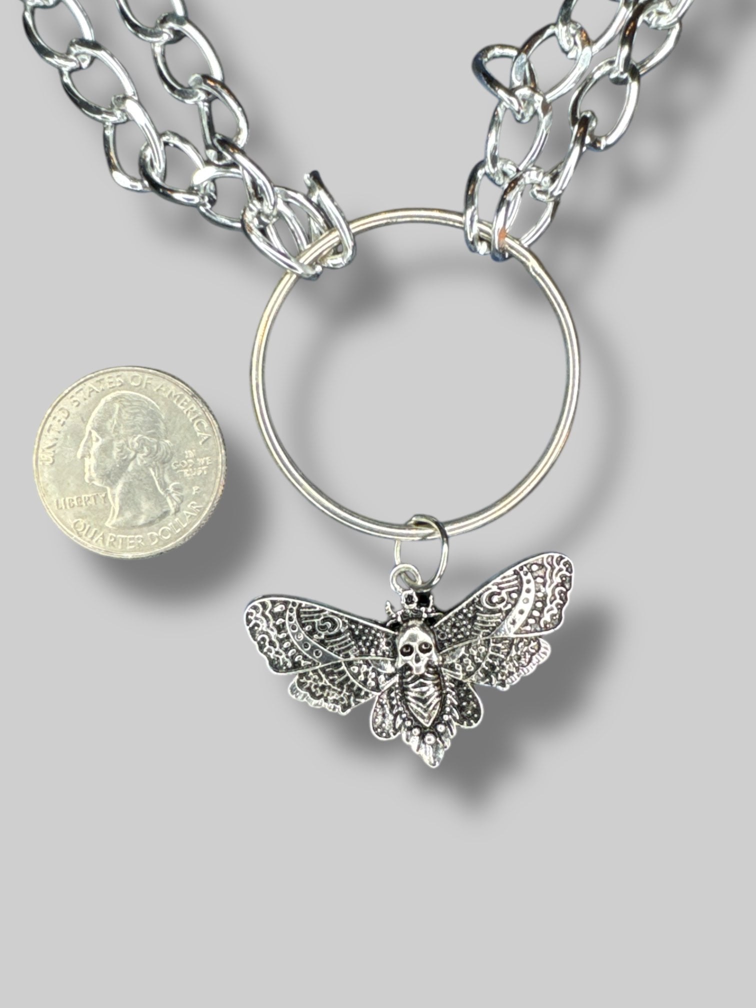 Silver tone chain link necklace with O ring and moth pendant