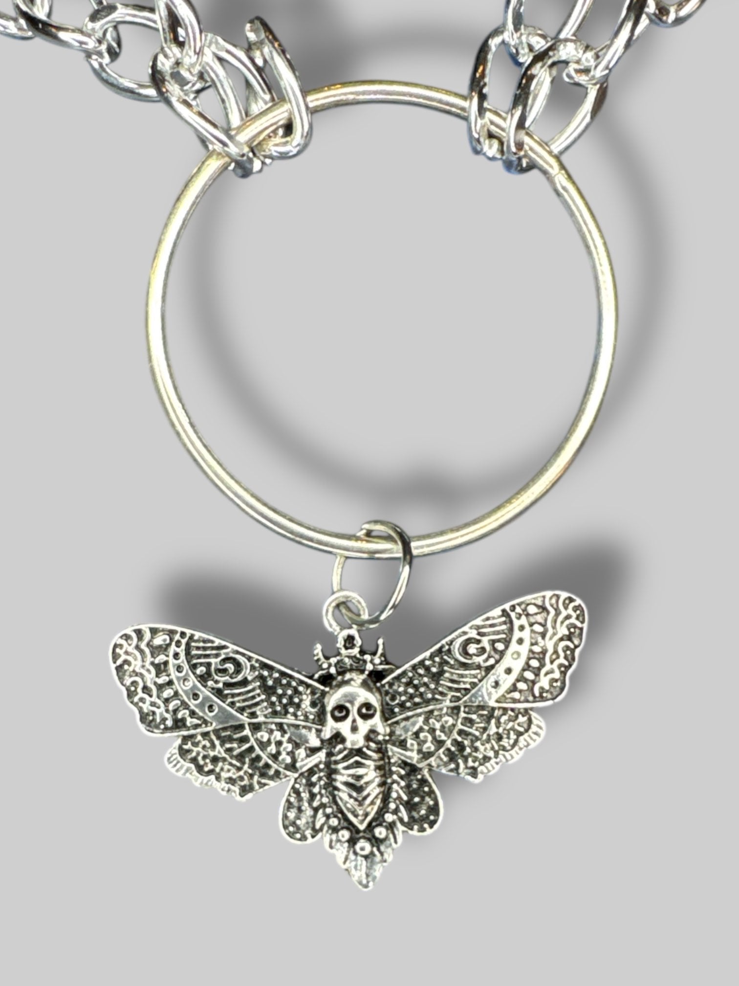 Silver tone chain link necklace with O ring and moth pendant