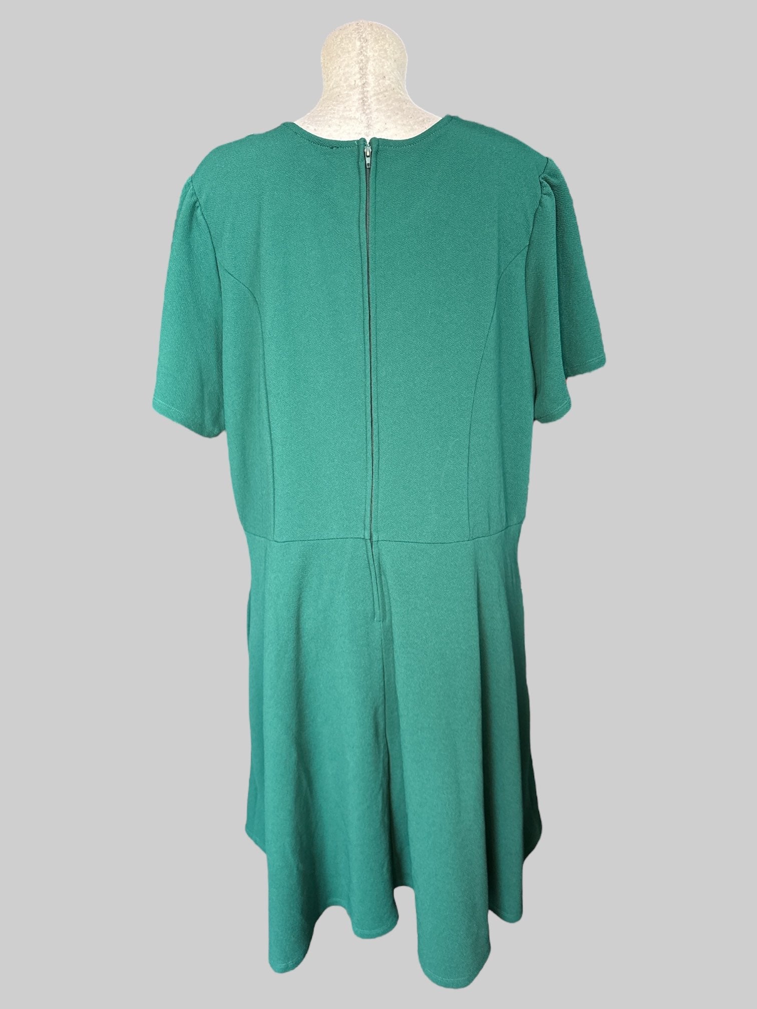 3X Dark green short sleeve dress with white detail on neckline, zipper on back, and pockets