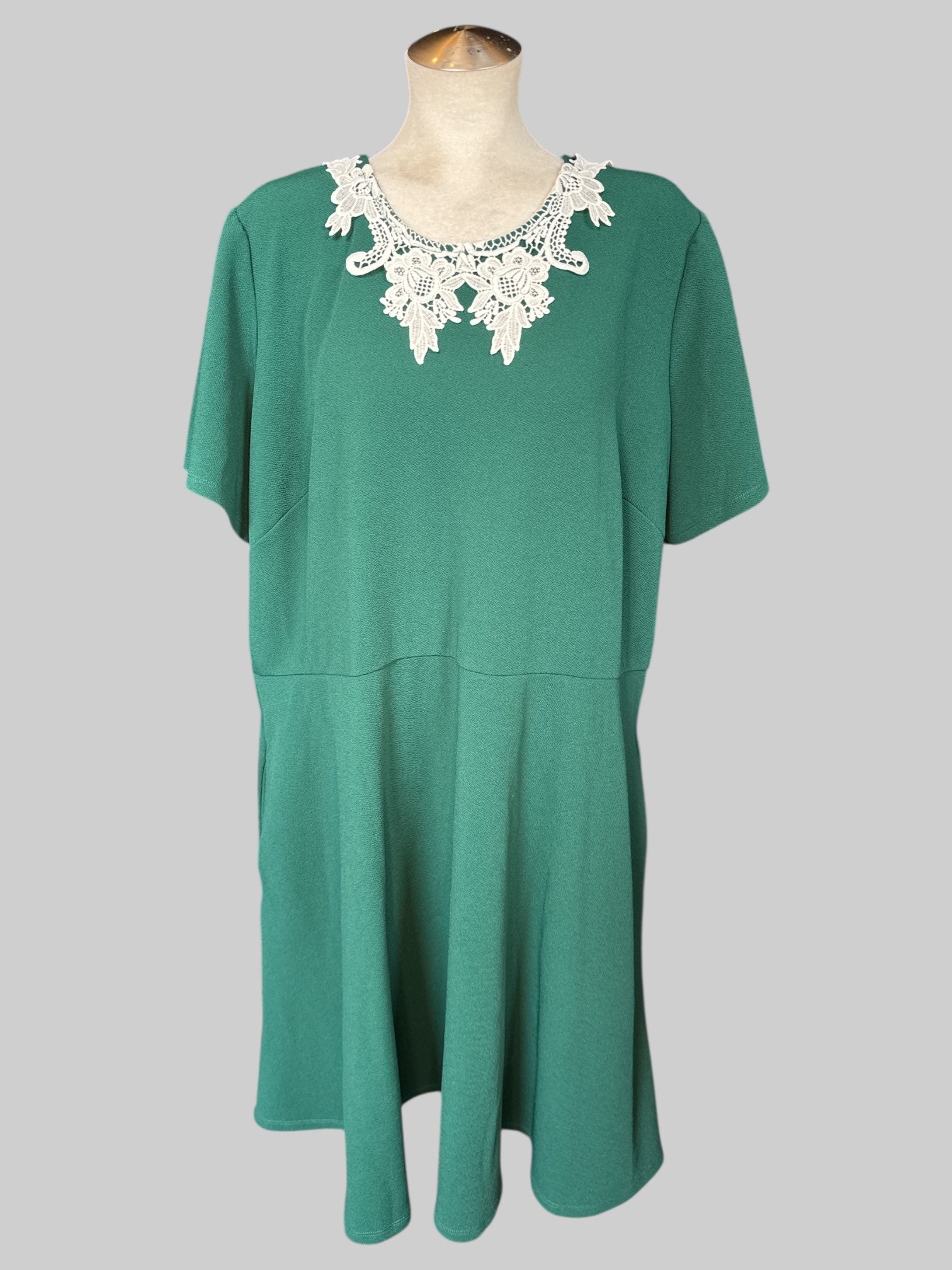 3X Dark green short sleeve dress with white detail on neckline, zipper on back, and pockets