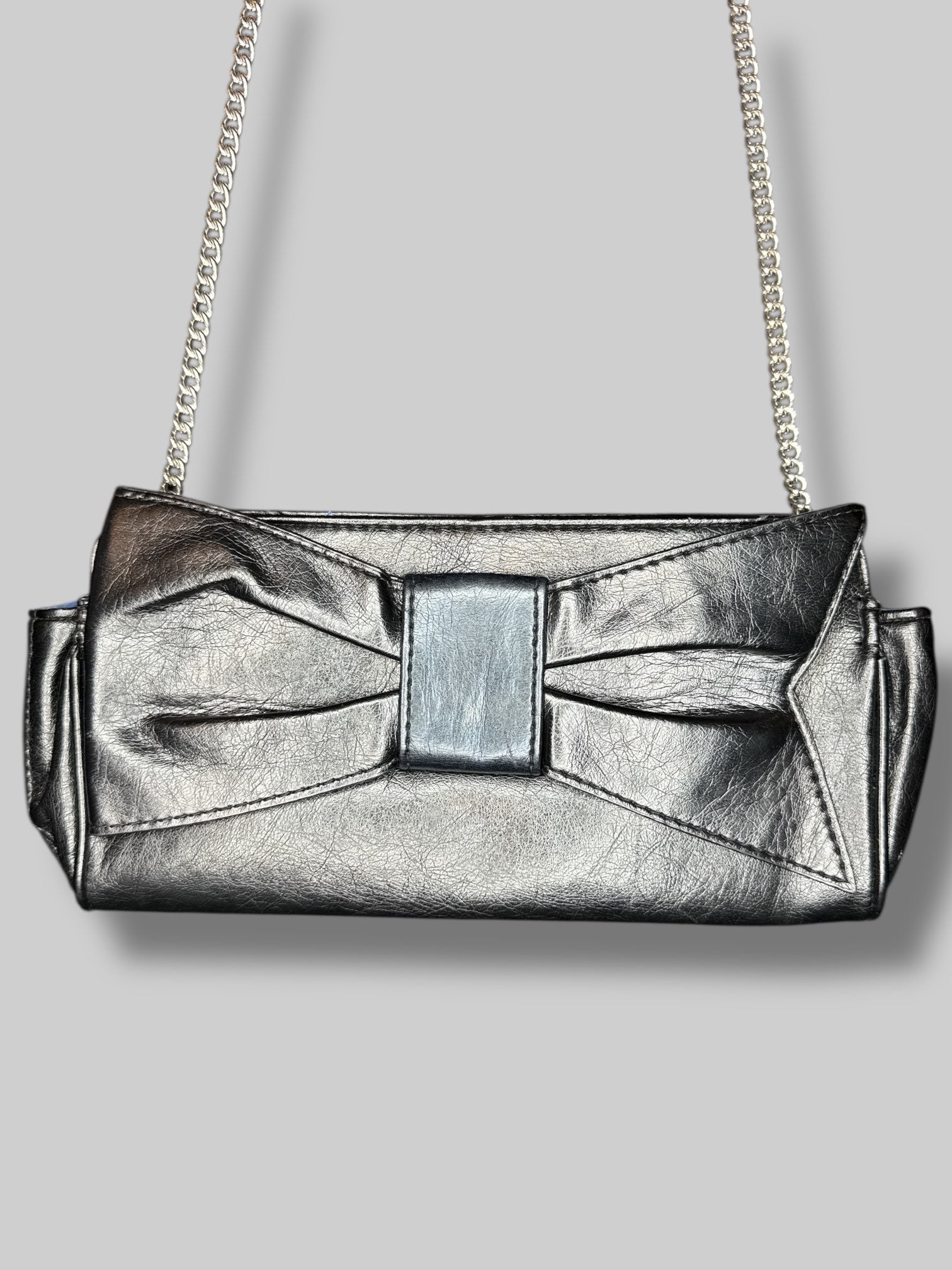Vintage black leather purse, with chain, shoulder strap, snap button closure, and decorative bow on outside