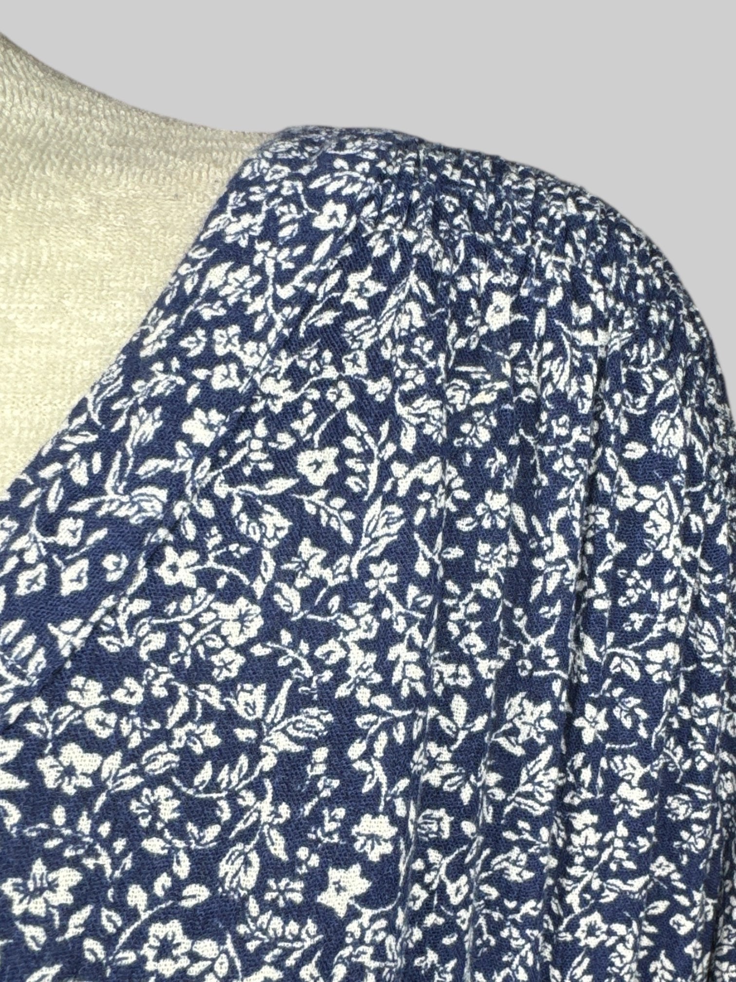 5X Blue and white floral long sleeve top with button on collar, shirred shoulders, and sleeves with buttons