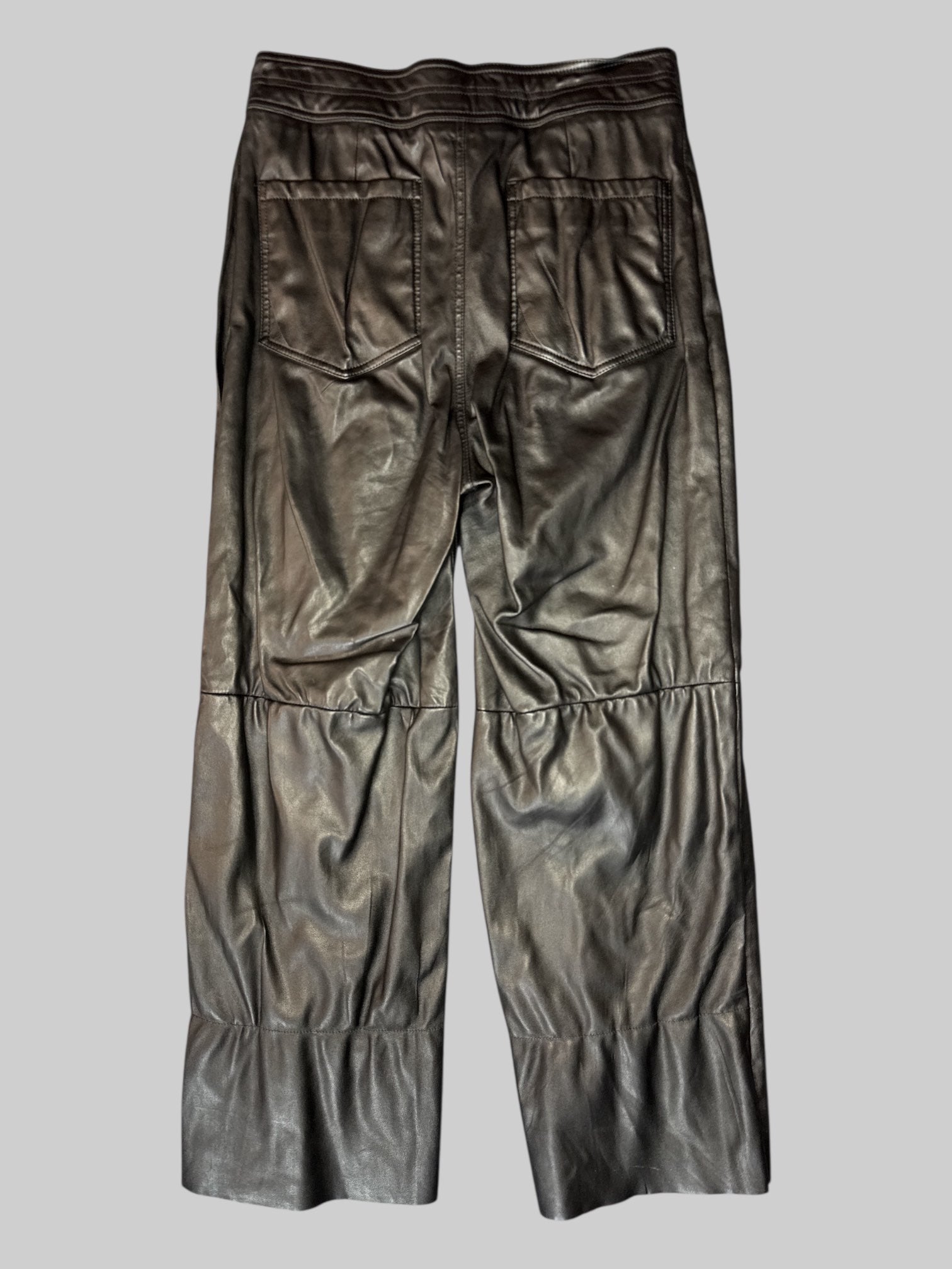 M A Piece Apart black leather pants with pockets, panel design, and cut bottom hems