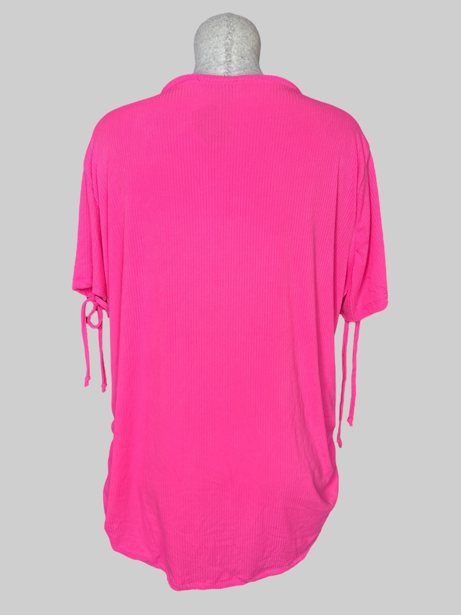 4X Pink short sleeve top with ribbed texture, lacing on neckline, cinching on sides, and ties on sleeves