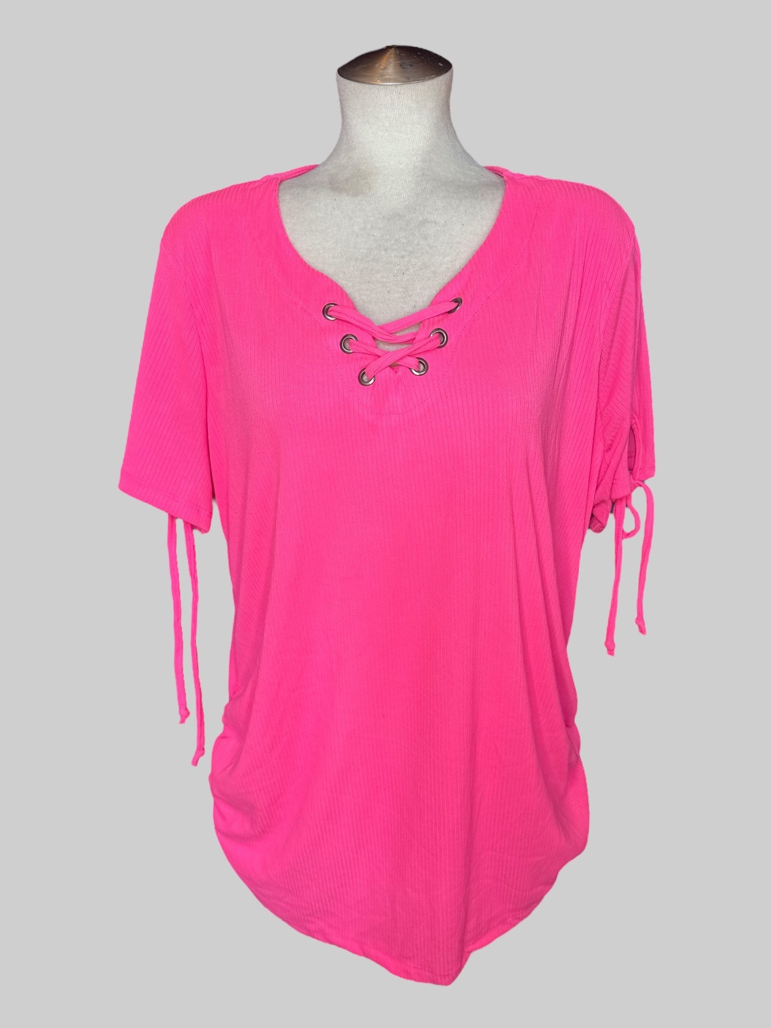 4X Pink short sleeve top with ribbed texture, lacing on neckline, cinching on sides, and ties on sleeves
