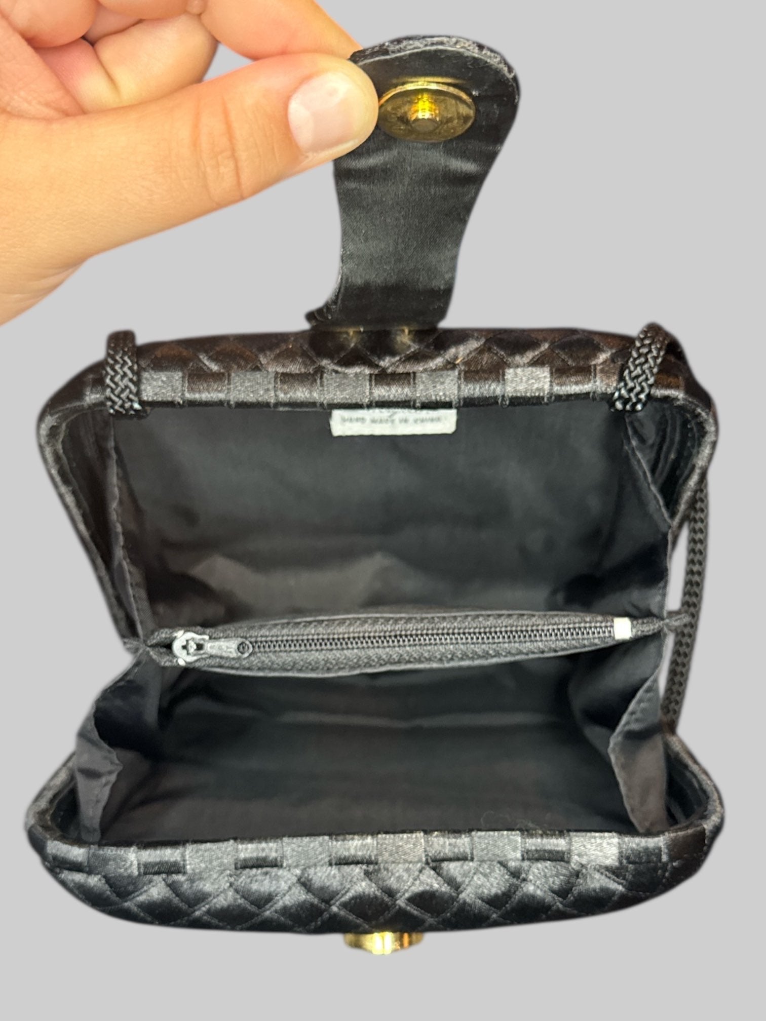Vintage black woven purse with braided shoulder strap, snap button claspe, and multiple pockets