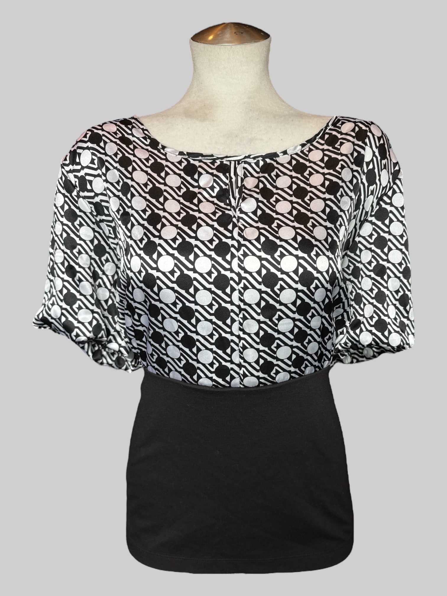 1X Black top with a geometric black and white pattern