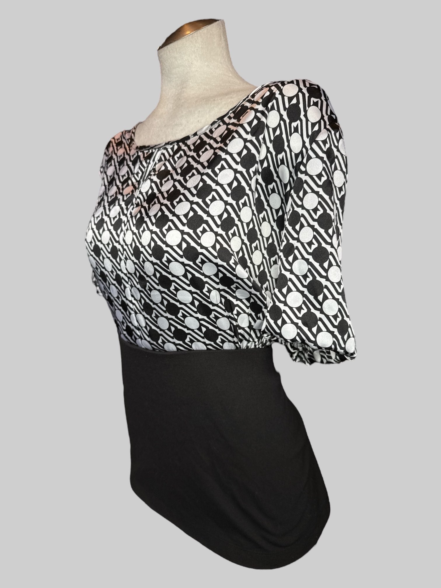 1X Black top with a geometric black and white pattern