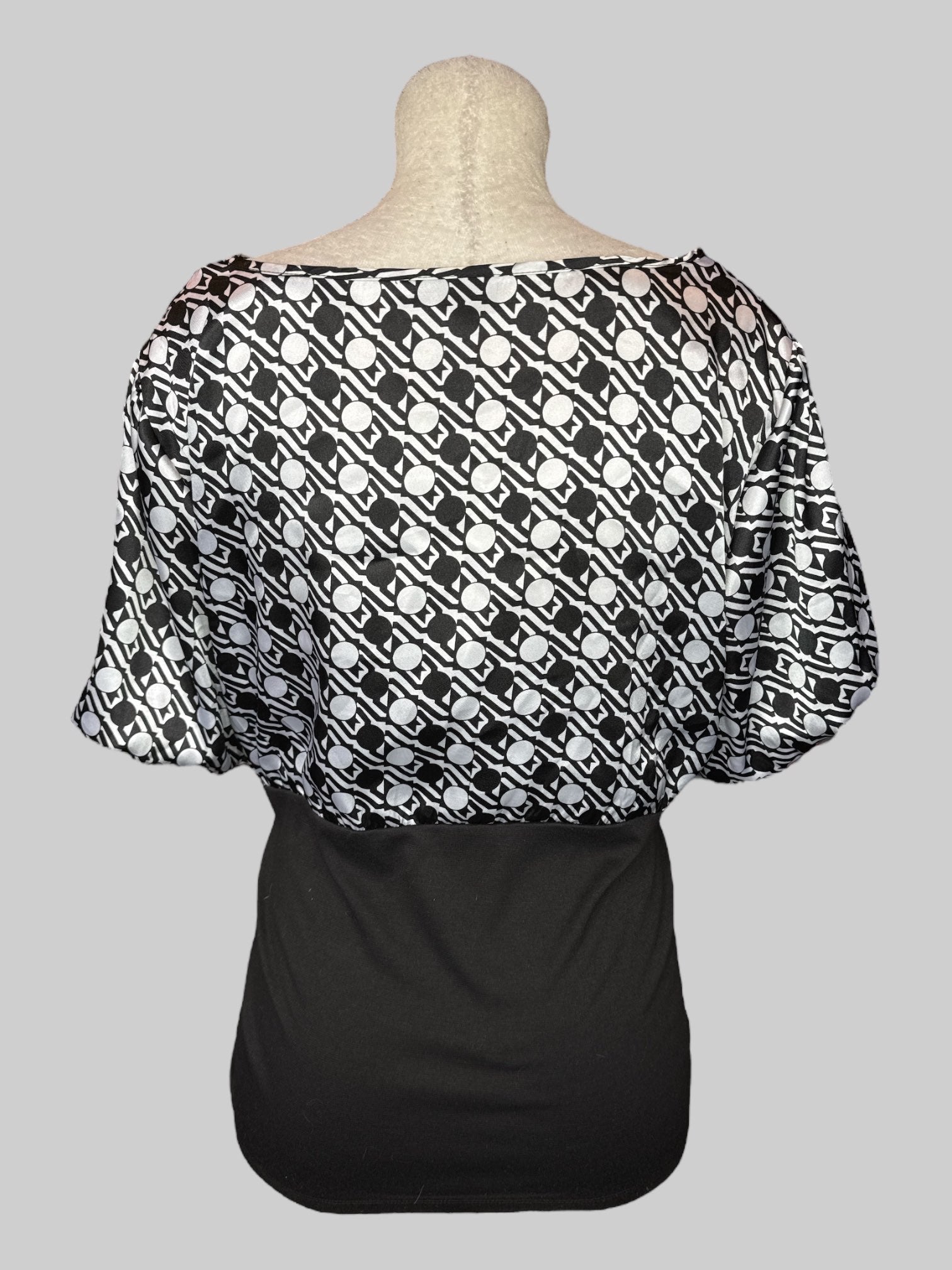 1X Black top with a geometric black and white pattern