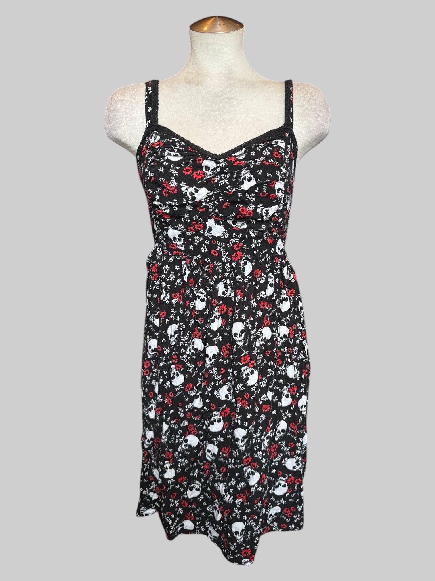 2X Black fit and flare dress with white skulls, white and red florals, and shirred back