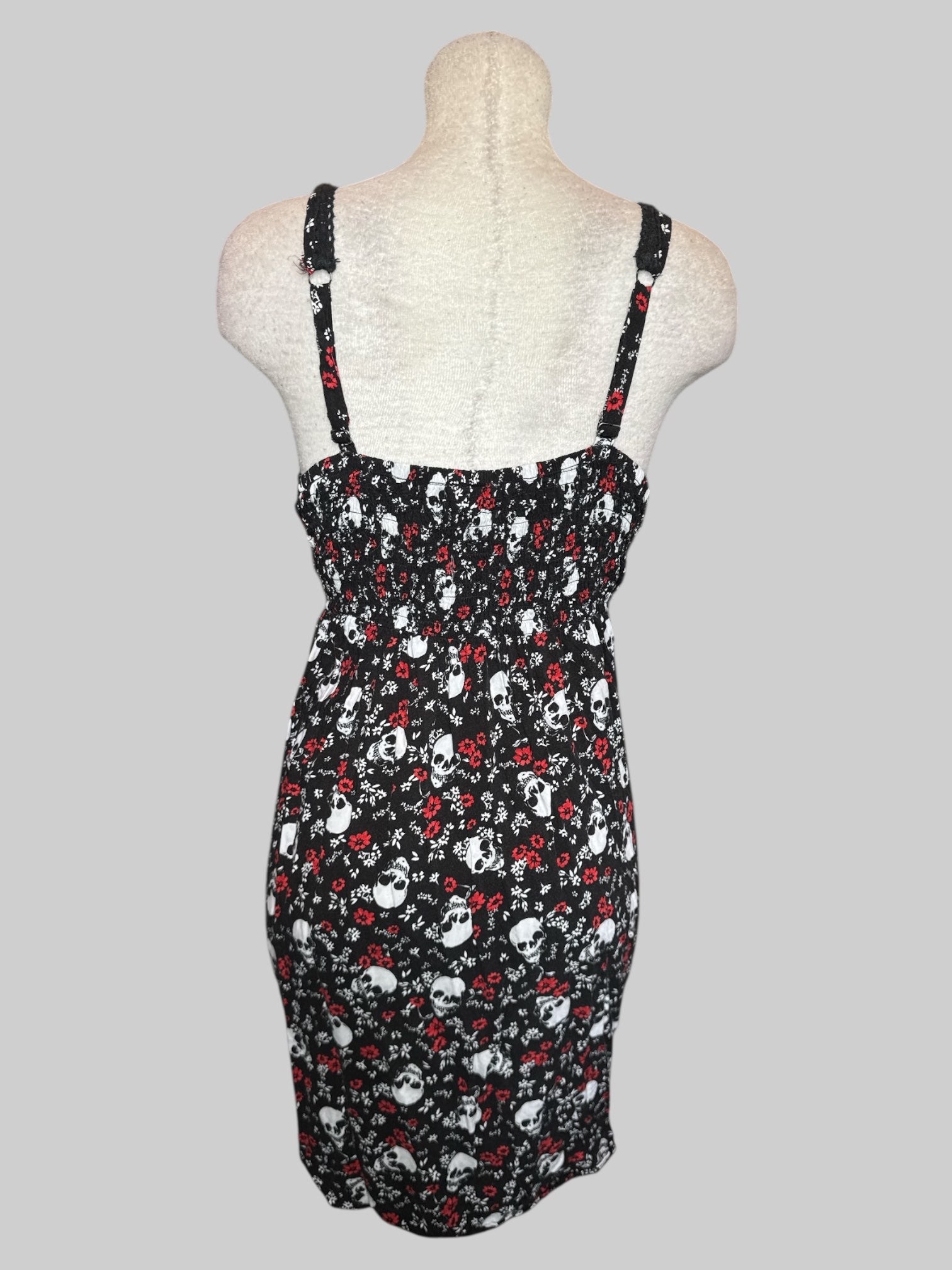 2X Black fit and flare dress with white skulls, white and red florals, and shirred back