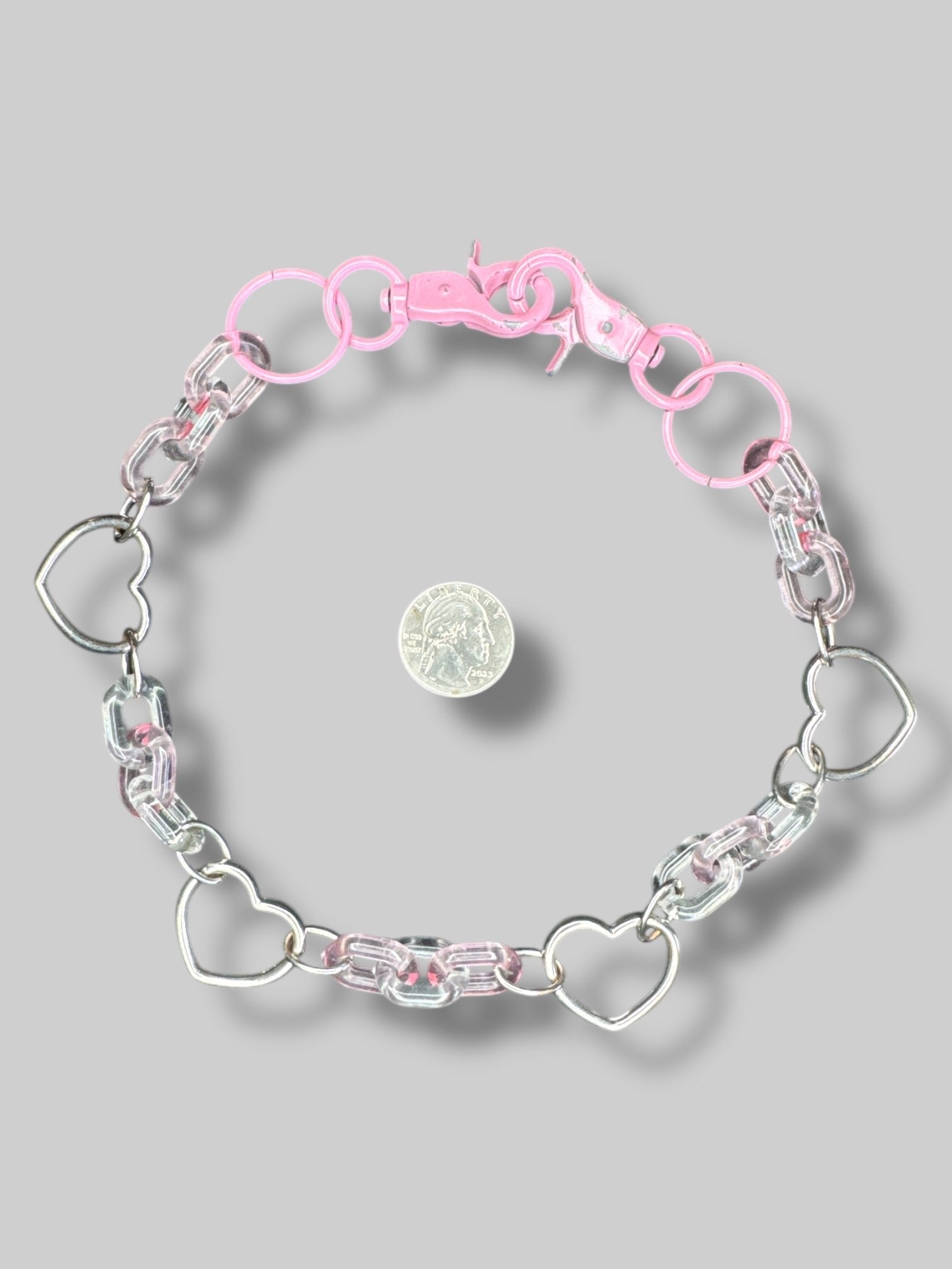 Pink silvertone and clear plastic chain with clasp closures on both sides