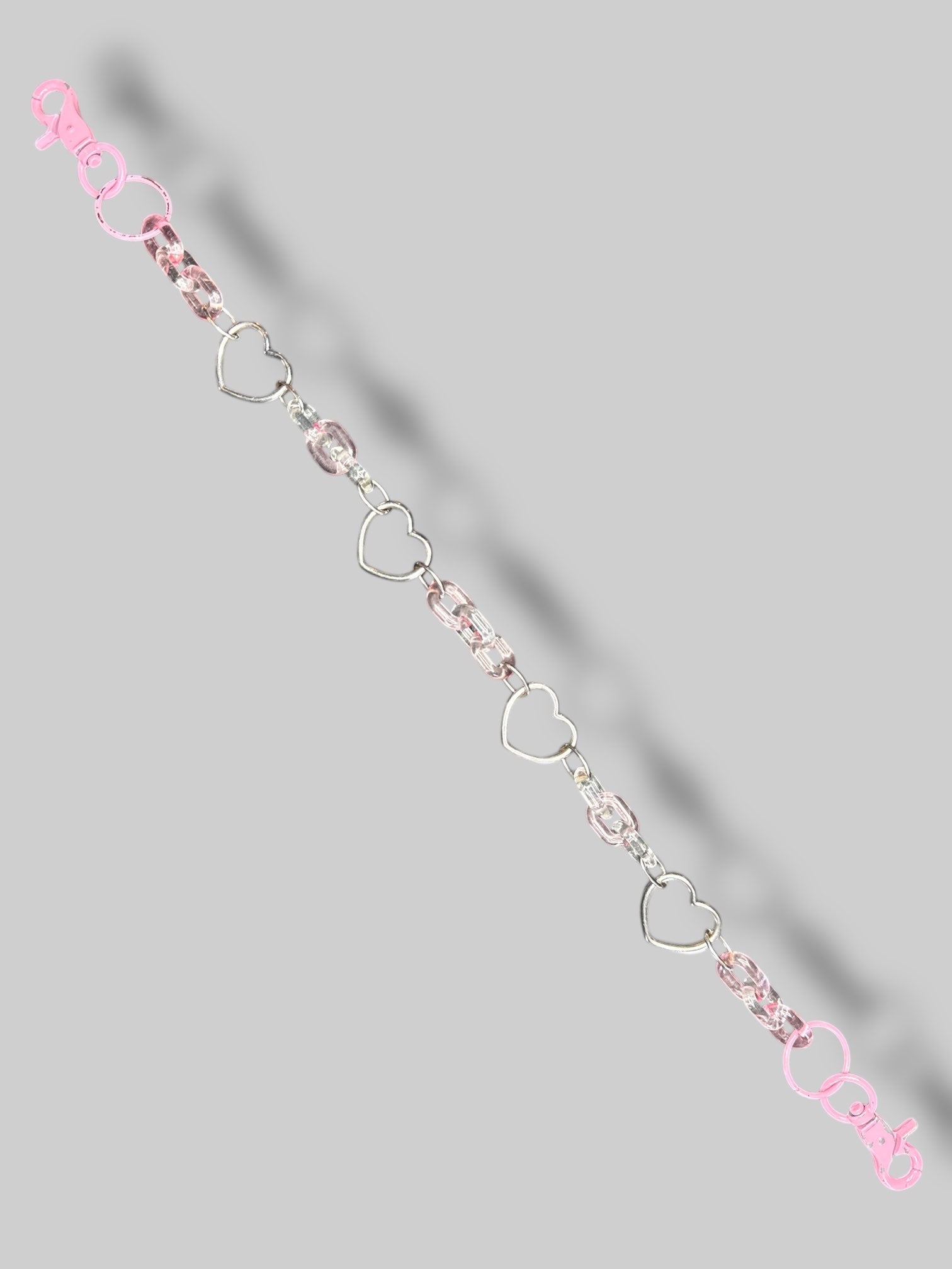 Pink silvertone and clear plastic chain with clasp closures on both sides