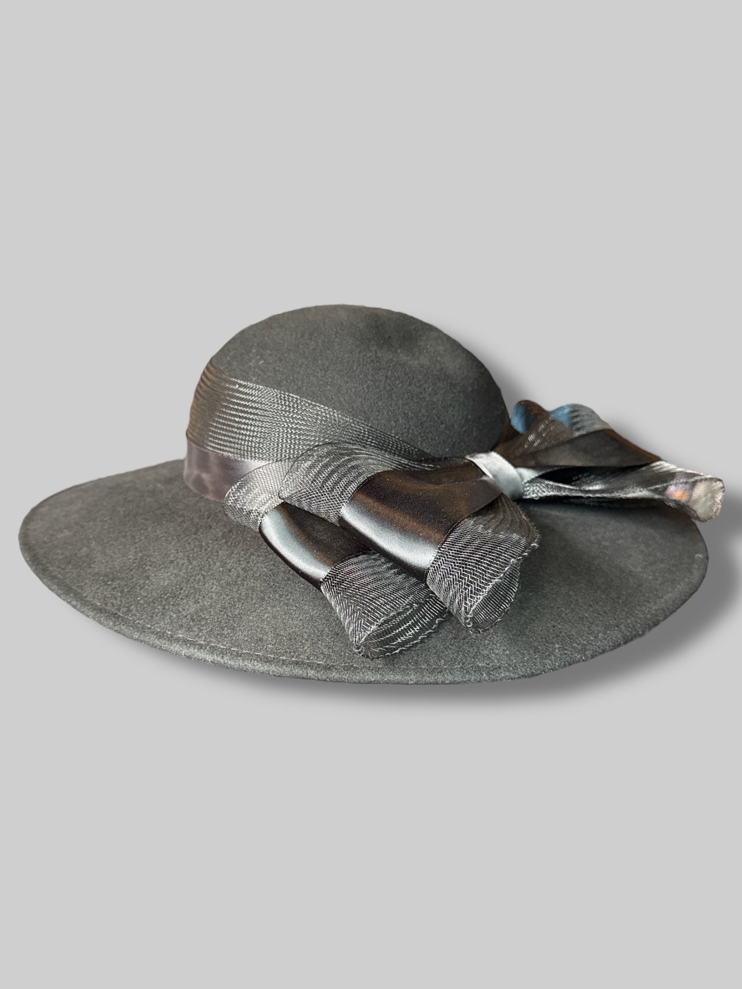 Black wide brim hat with mesh, netting and ribbon bow, and iridescent feathers