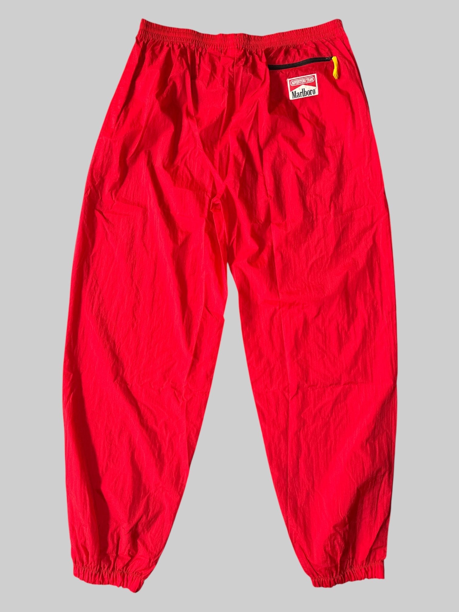 0X Vintage Marlboro Adventure Team red track pants with zipper pocket on back, and stretchy waist with withdrawal string inside