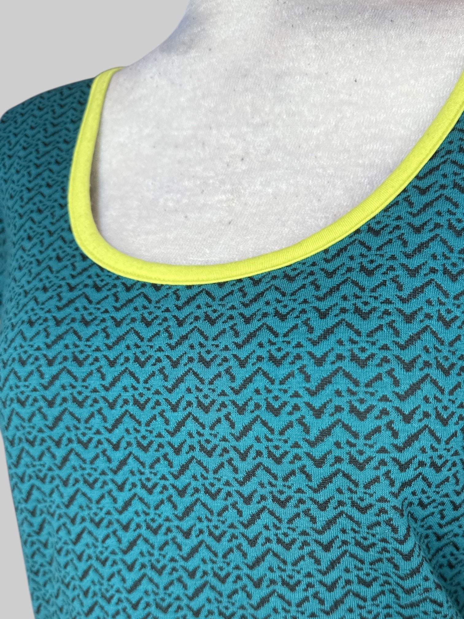 M Greenish blue top with black geometric pattern, back cut out, and yellow hem line
